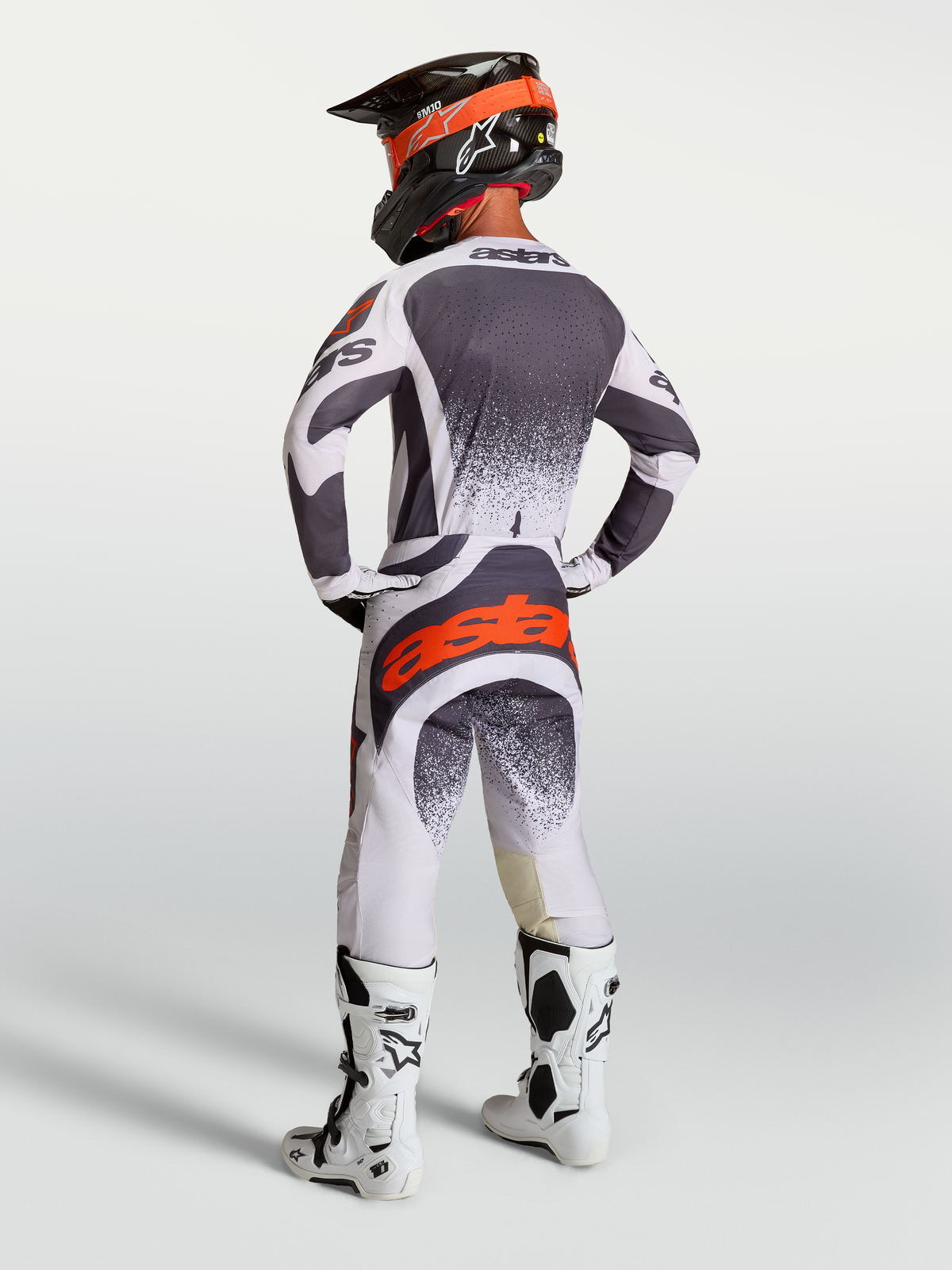Alpinestars Techstar Swan, camisola e calças de motocross para homem, cinzento e branco com pormenores vermelho fluo, vista traseira no modelo