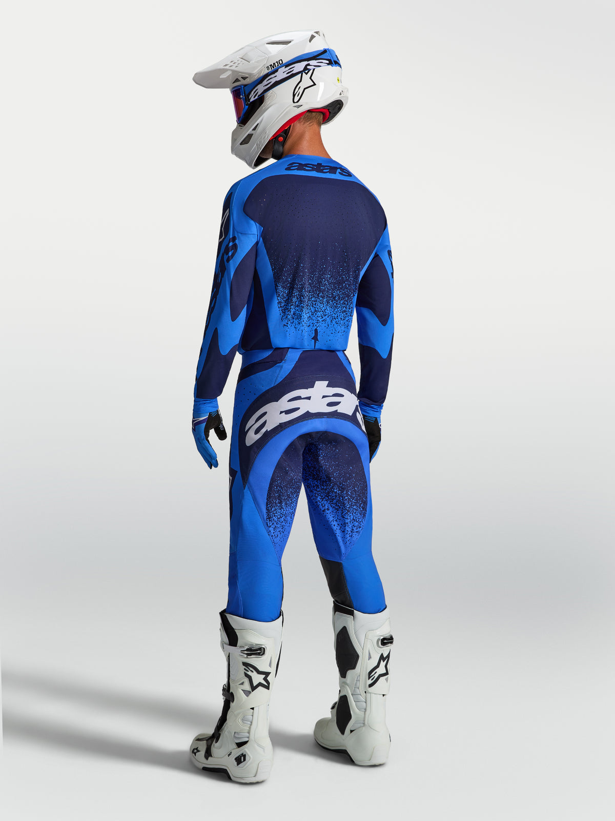 Alpinestars Calças Techstar Swan, calças de motocross para homem, azuis e brancas, vista traseira com ajuste de corrida.