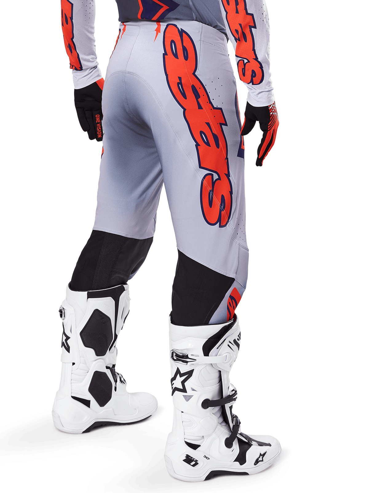 Alpinestars 2025 Supertech Lipan Pants, calças de motocross, cinzentas e laranja fluo, usadas com camisola a condizer e botas brancas, vista traseira com grande grafismo Alpinestars em laranja, painéis elásticos pretos, equipamento profissional de motocross