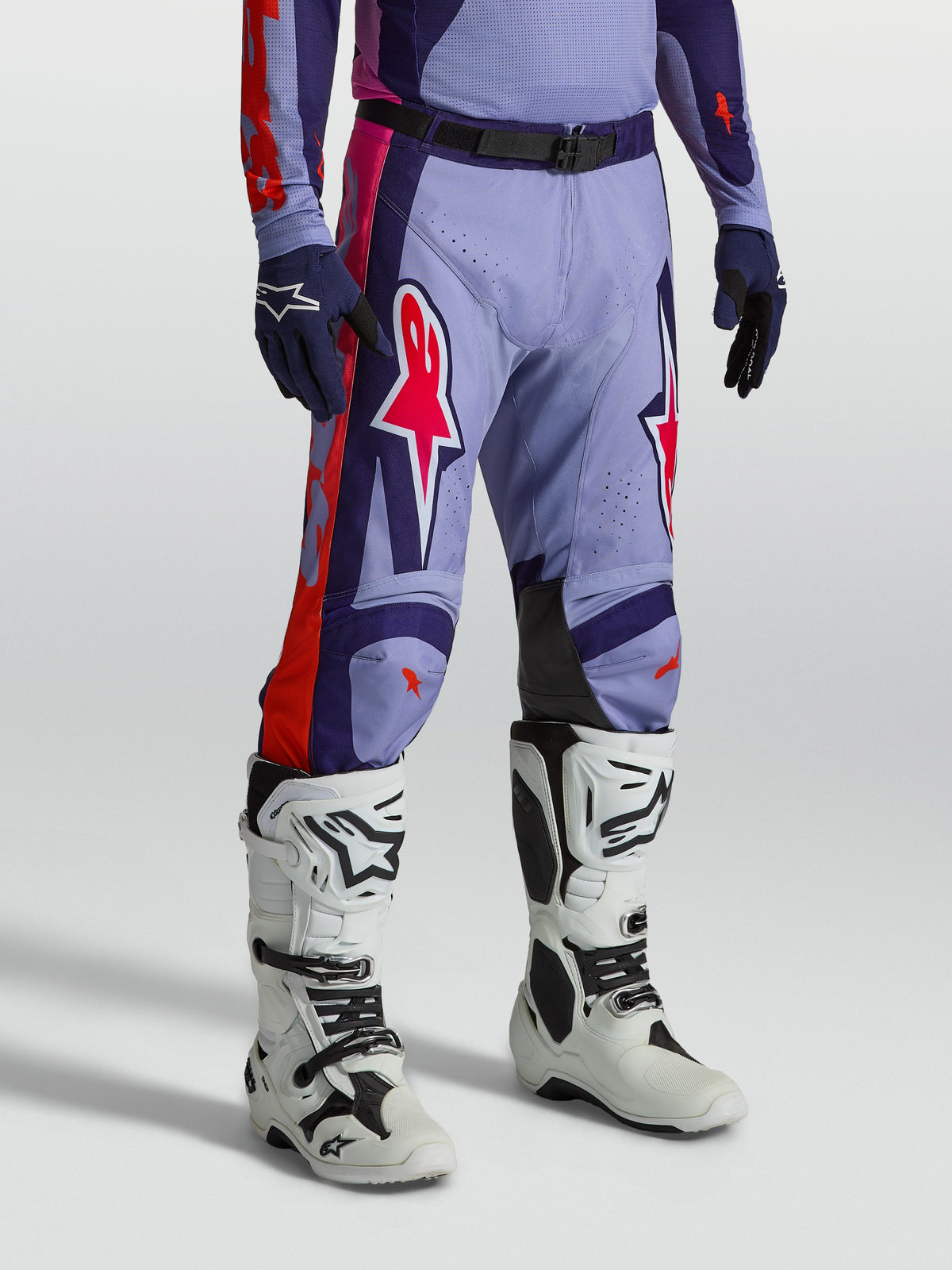 Alpinestars Racer Air Hunt, calças de motocross ventiladas roxas e rosa, modelo com botas brancas para off-road.