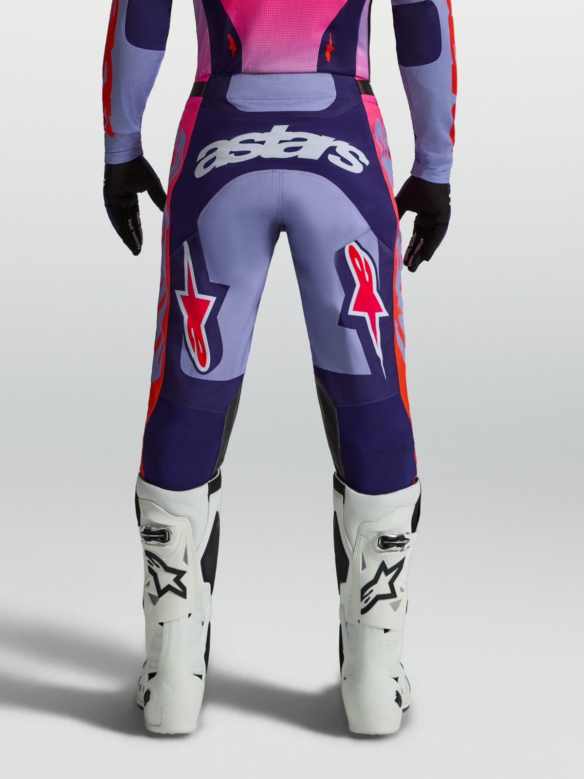 Alpinestars Calças Racer Air Hunt, calças de motocross para homem, roxas e rosa fluo, com painéis de malha ventilada, vista traseira no modelo.