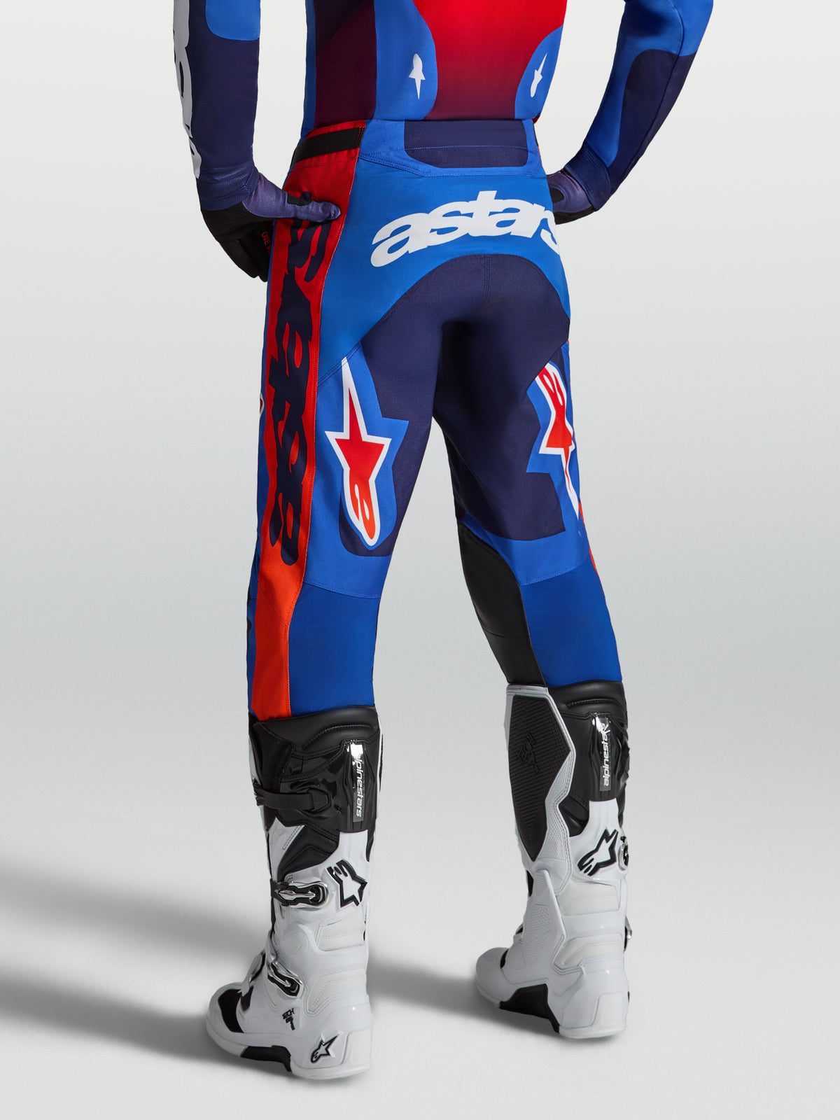 Alpinestars Racer Hunt, calças de motocross para homem, azul e vermelho, ajuste de corrida pré-curvado, vista traseira para performance em todo-o-terreno.