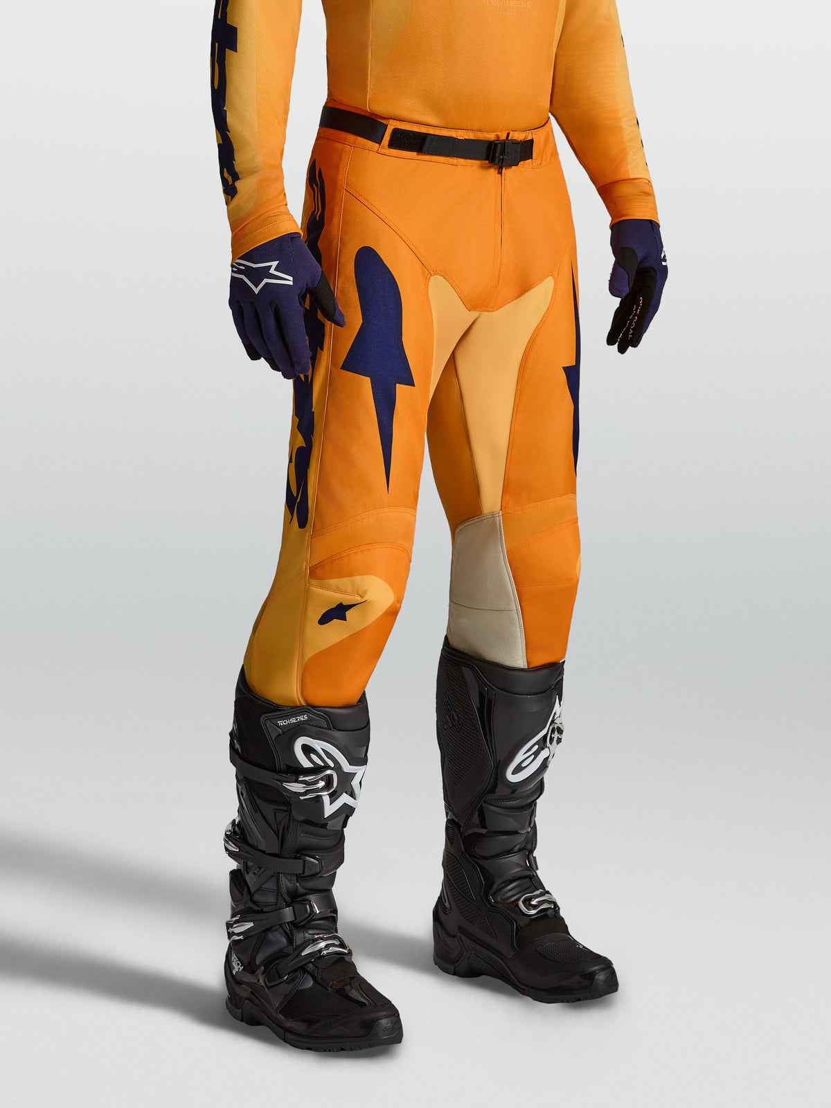 Alpinestars Racer Amber, calças de motocross para homem, laranja e azul escuro, com pernas pré-curvadas e inserções elásticas para maior mobilidade em todo-o-terreno.