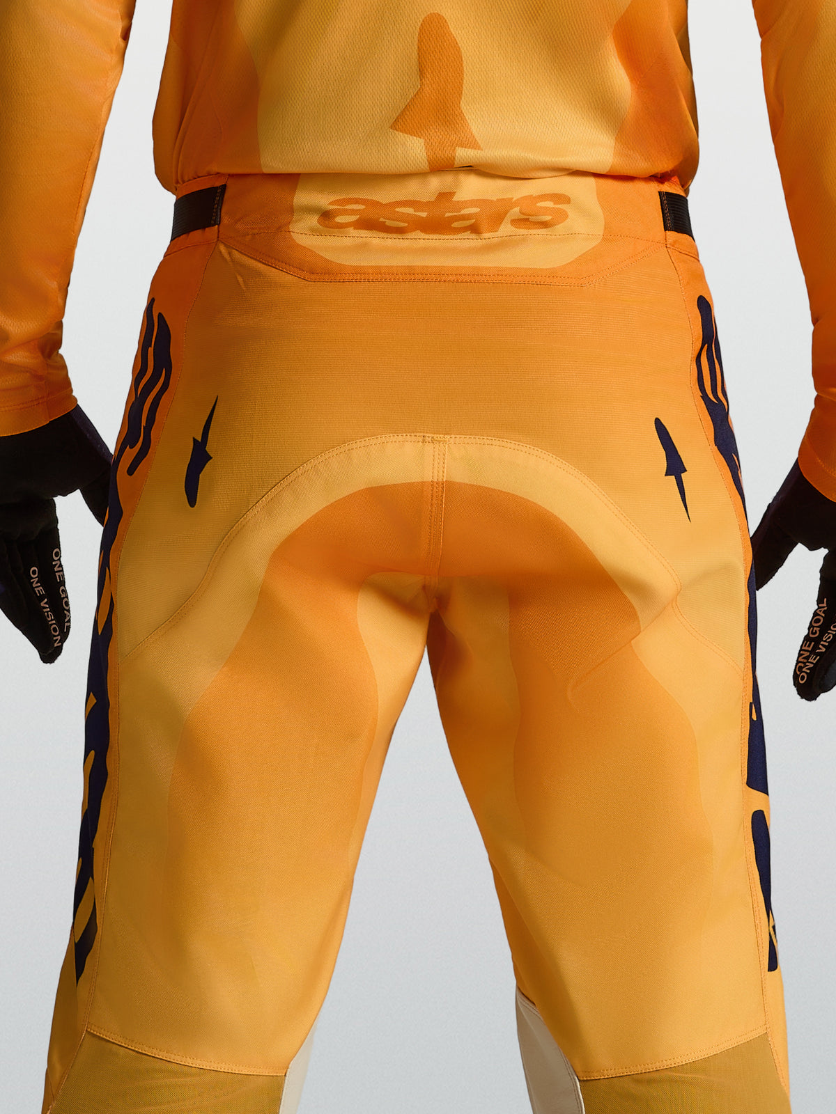 Calças Alpinestars Racer Amber de motocross para homem, laranja e azul escuro, com assento reforçado e logótipo Astars.