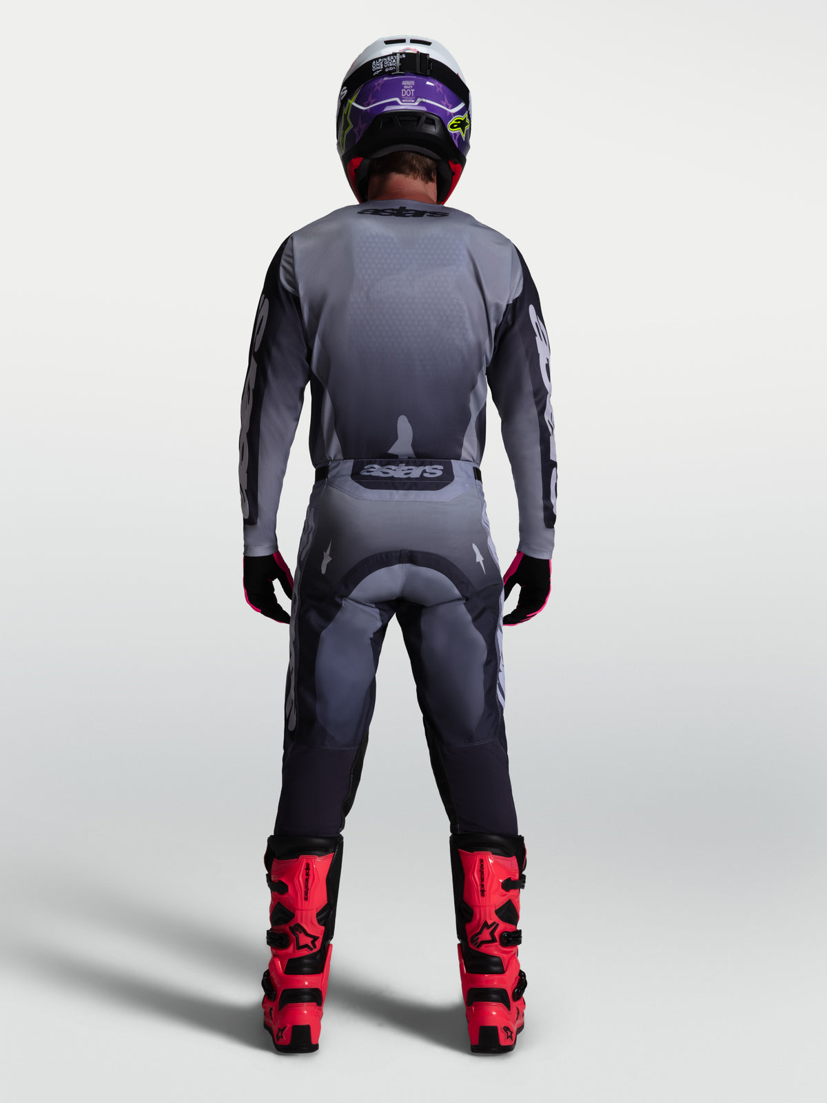 Alpinestars Racer Amber Pants, gray and light lilac motocross gear set for men, back view with red boots.