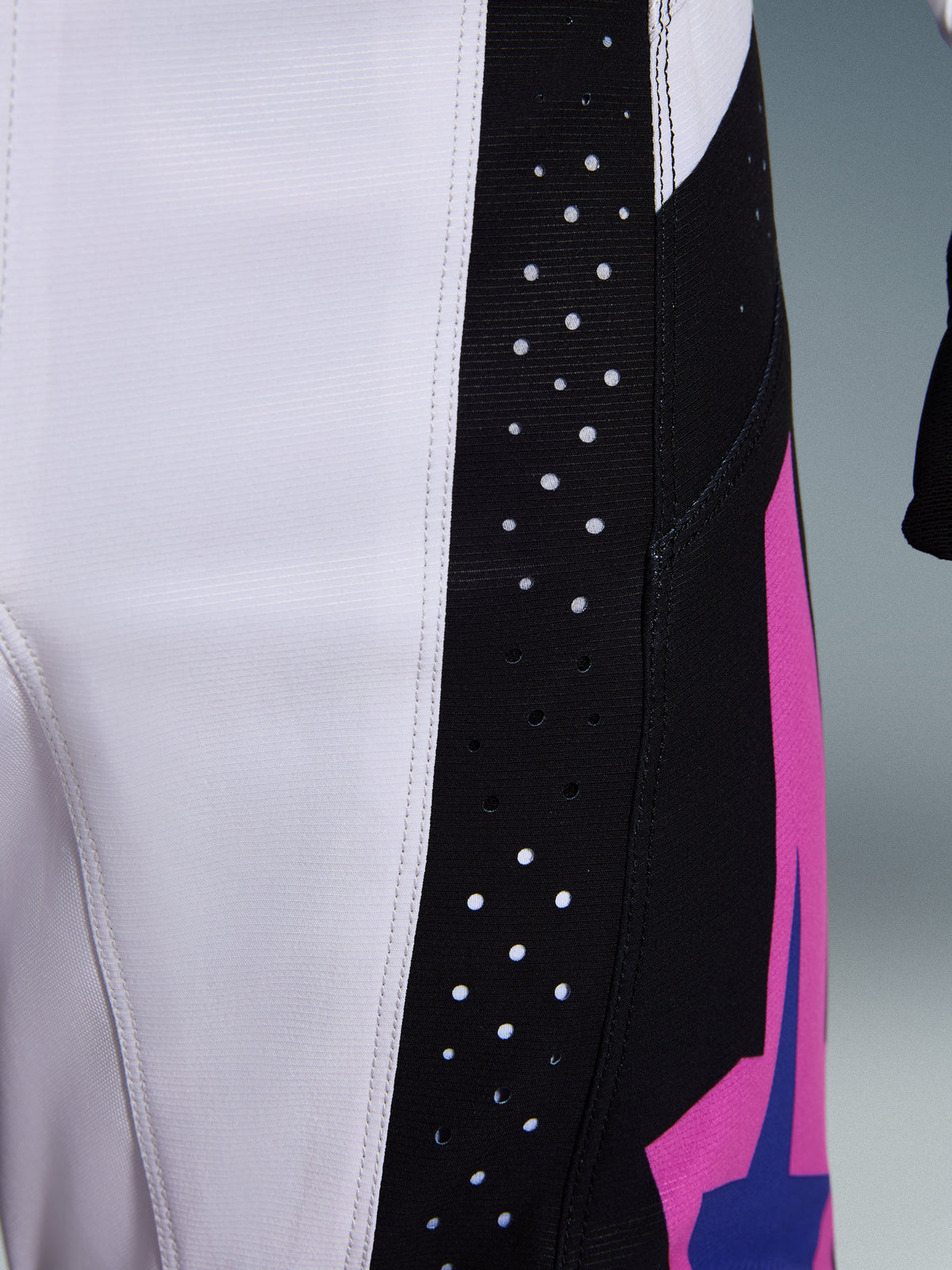 Alpinestars 2026 Techstar Knif Pants, calças de motocross, pretas, cinzento claro e roxas, pormenor das perfurações cortadas a laser no painel lateral preto para ventilação, construção durável em tecido ripstop