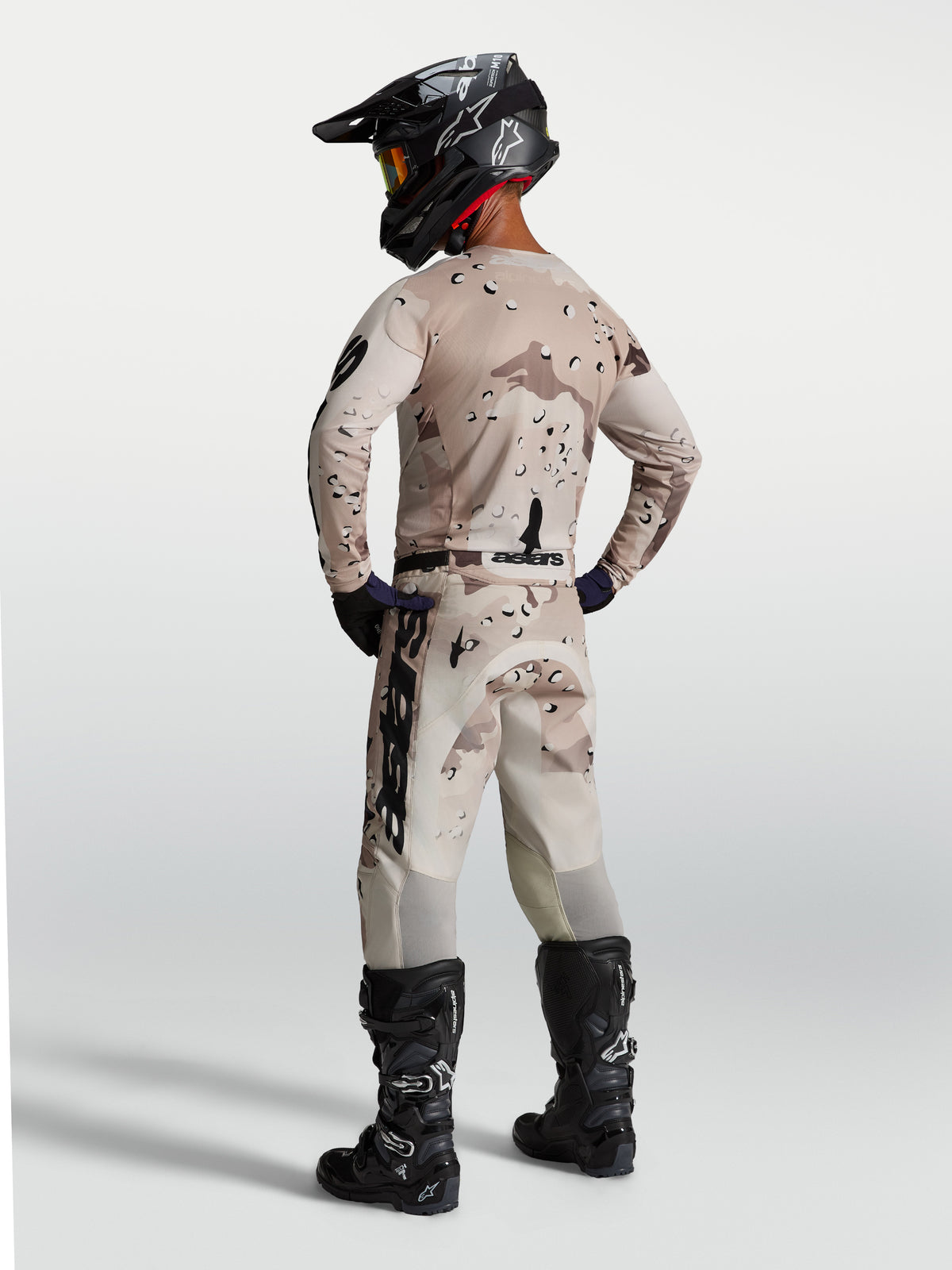 Calças Racer Lone da Alpinestars para homem, em polifibra 600D, bege camuflado e pretas, vista traseira no modelo.