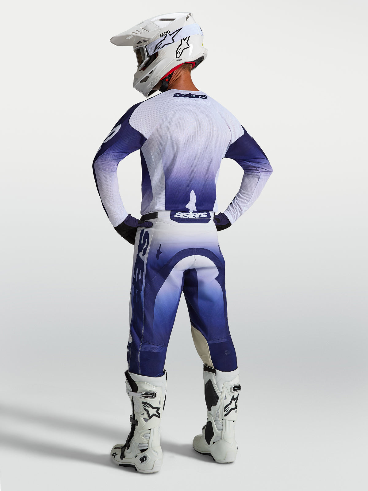Alpinestars Racer Air Amber Pants, Men's Blue and White Motocross Pants, high-airflow perforated construction, shown from behind on a rider with white boots and helmet.