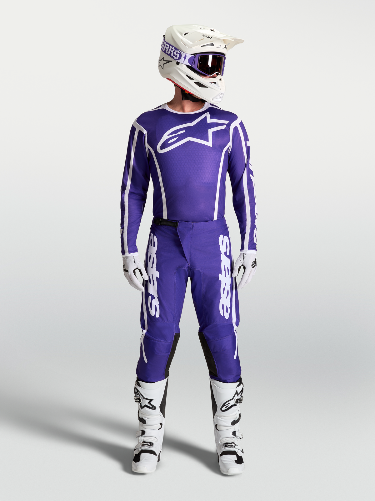 Alpinestars Fluid Apex V2, calças de motocross para homem, azul escuro e branco, apresentadas com camisola e botas de motocross a condizer