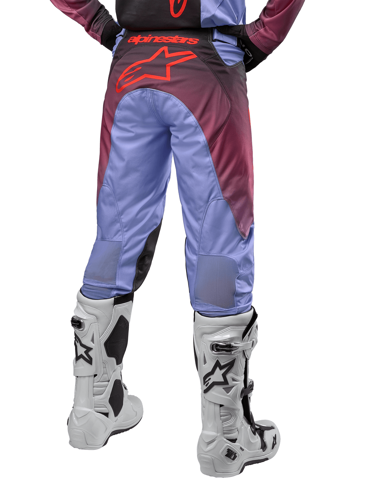 Alpinestars 2024 Racer Hoen Pants, calças de motocross, roxo Lavan e preto, vista traseira mostrando um grande logótipo de estrela vermelho no assento, usadas com botas de motocross brancas, com painéis elásticos respiráveis na parte inferior das pernas