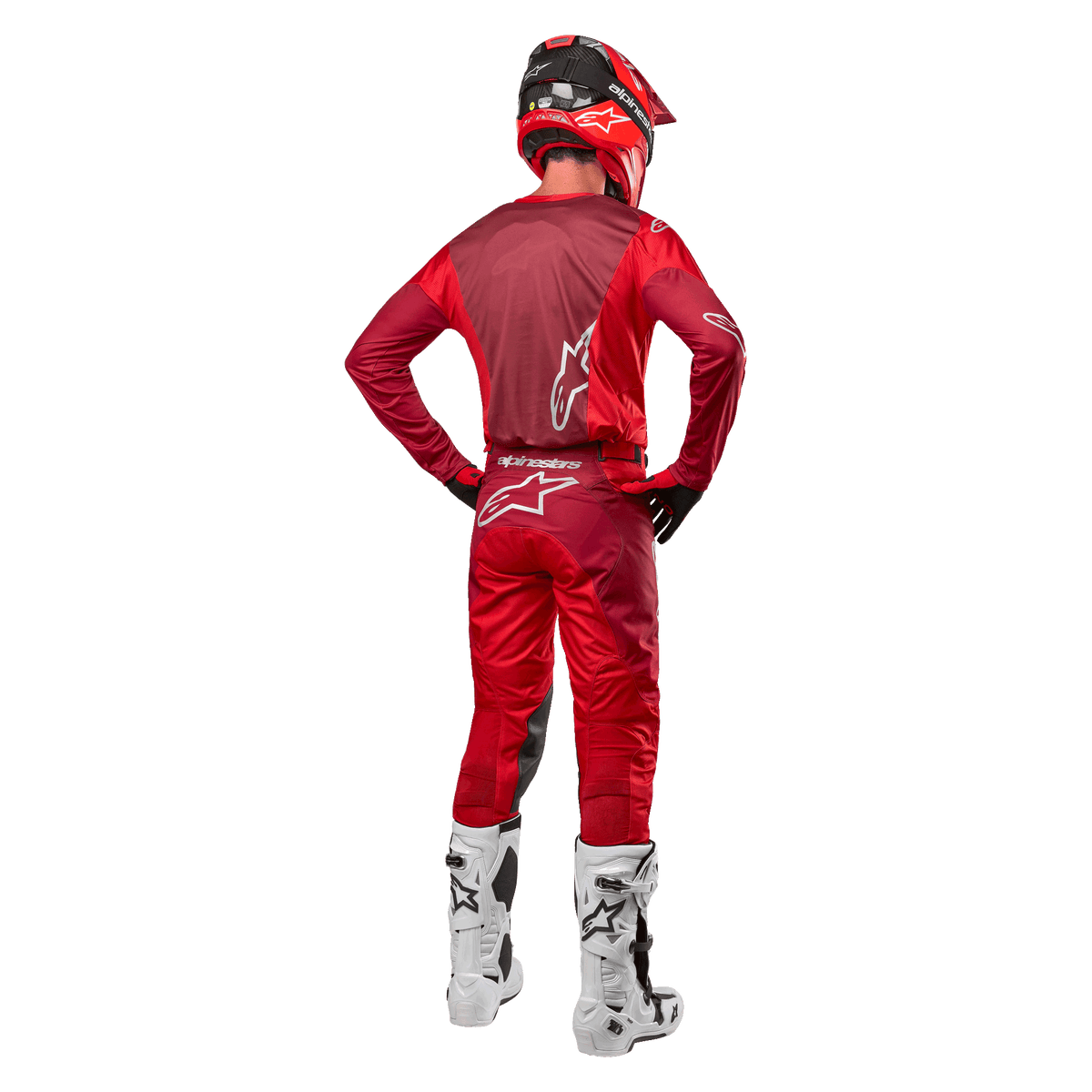 Calças Alpinestars 2024 Racer Hoen e camisola a condizer em Mars Red Burgundy, vista traseira de um piloto de motocross com equipamento completo, incluindo capacete vermelho e botas brancas, destacando o ajuste atlético e a marca para corridas todo-o-terreno.