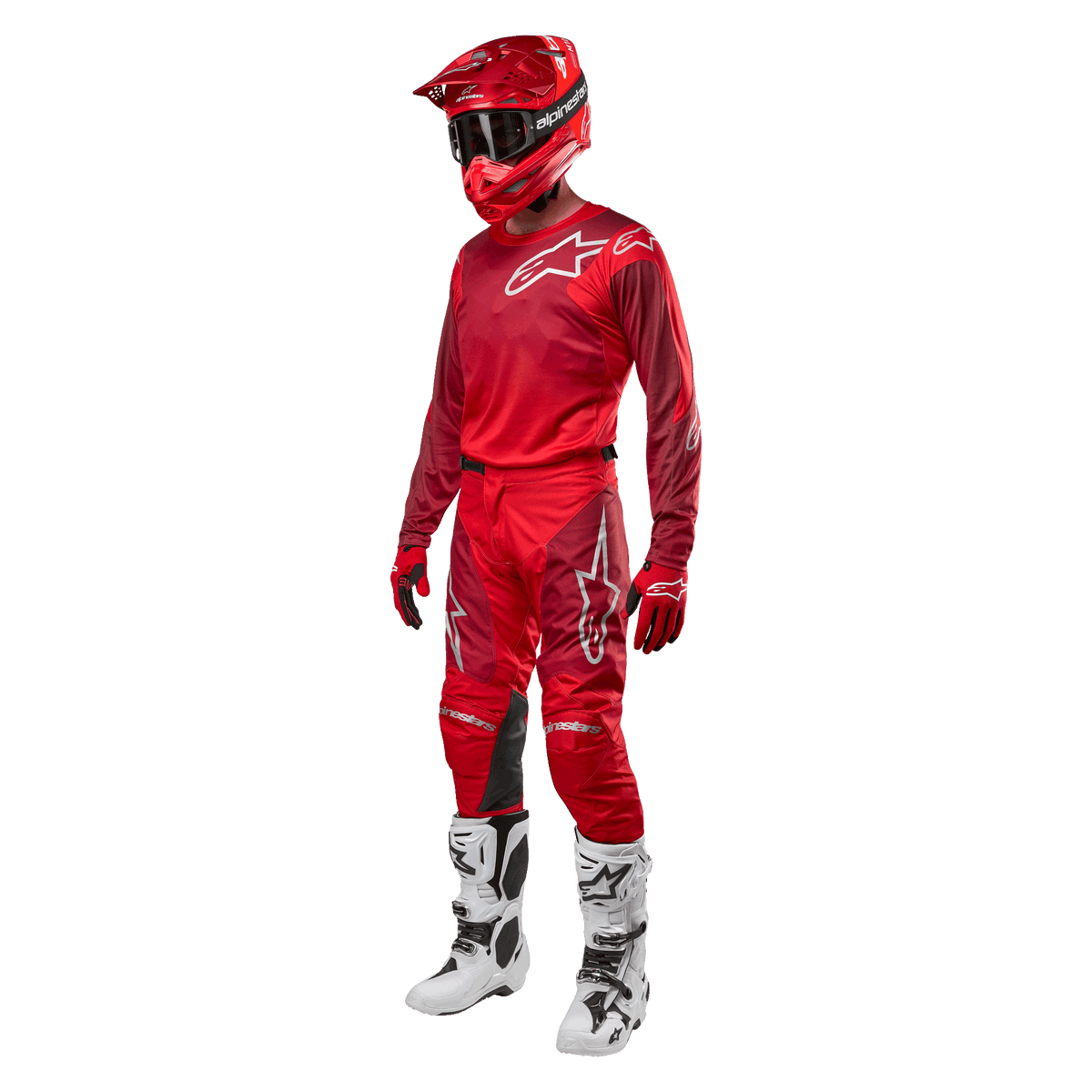 Piloto de motocross a usar equipamento completo de competição, calças e camisola Alpinestars 2024 Racer Hoen em Mars Red Burgundy, capacete vermelho, luvas vermelhas, e botas brancas e pretas, conjunto coordenado para corridas de todo-o-terreno
