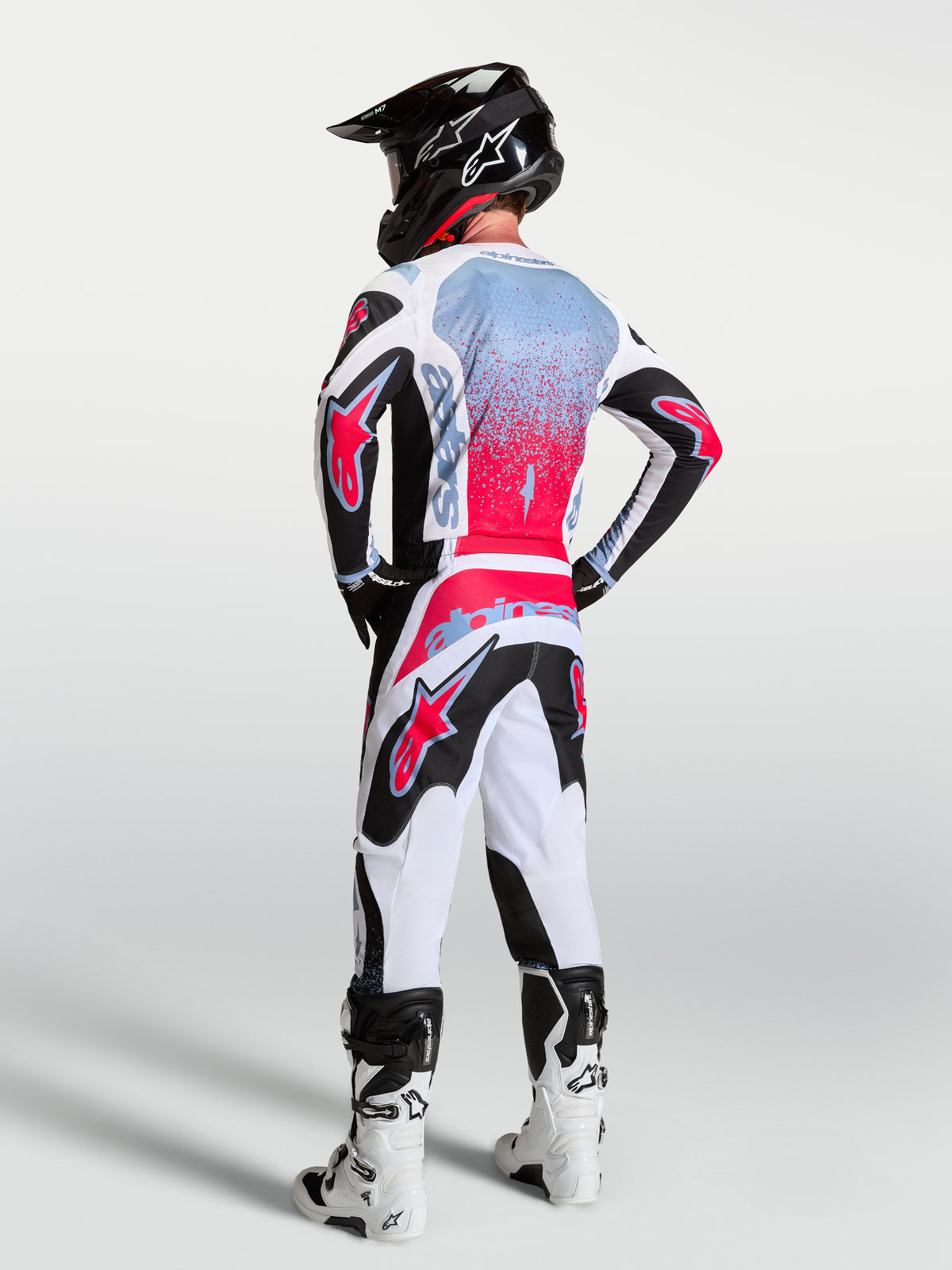 Alpinestars calças Fluid Drag, calças de motocross para homem, brancas e pretas com detalhes vermelhos, vista traseira no modelo.