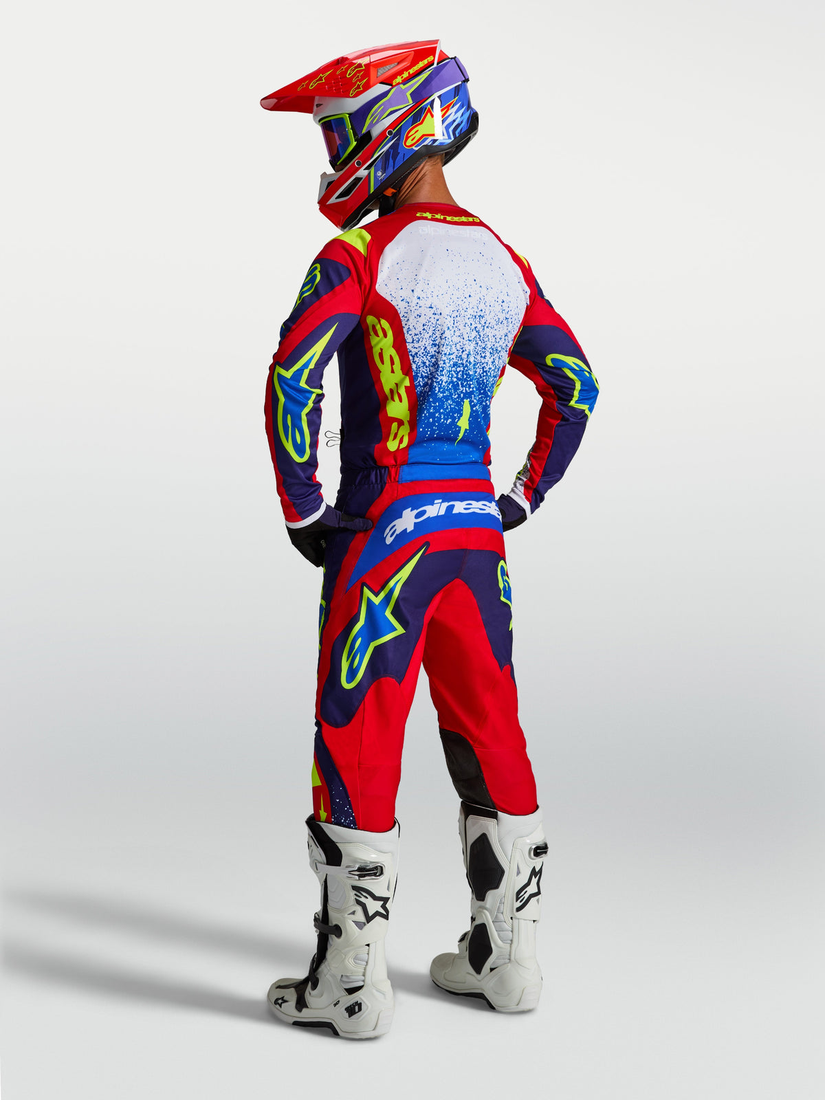 Alpinestars Calças Fluid Drag e Conjunto Fluid Drag, fato de motocross para homem, azul e vermelho, vista traseira em modelo.