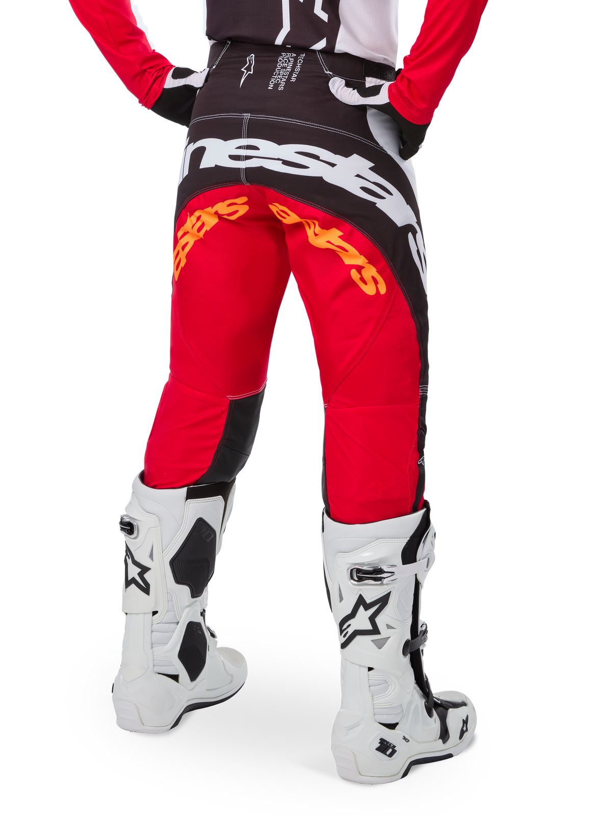 Alpinestars Limited Edition Techstar Deep Pants, calças de motocross, pretas, brancas e vermelho vibrante (High Red), vista traseira com logótipo Alpinestars branco em destaque no assento e branding laranja, usadas com botas técnicas brancas para corridas profissionais de todo-o-terreno