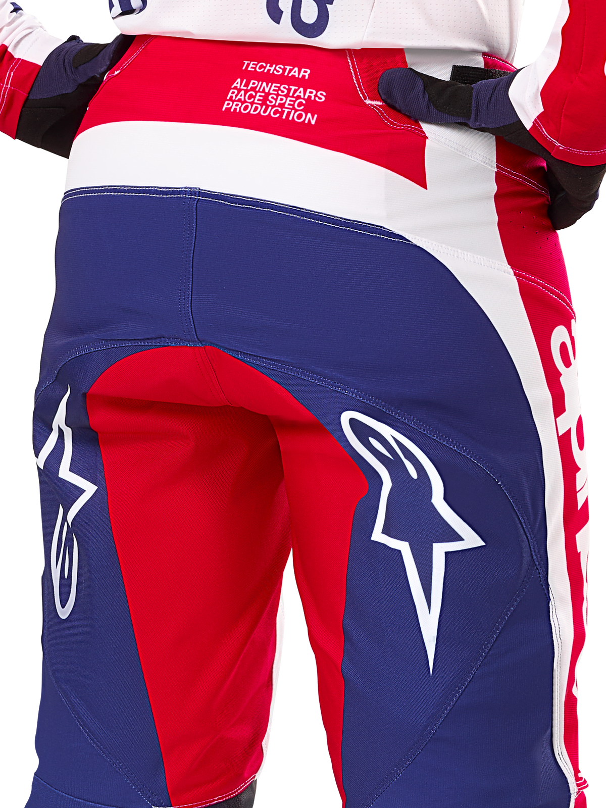 Alpinestars Techstar Fortitude Edição Limitada, calças de motocross, vermelhas, brancas e azuis, vista traseira com logótipos de estrela brancos no assento e marca Techstar Race Spec, têxteis de performance duráveis para corridas todo-o-terreno