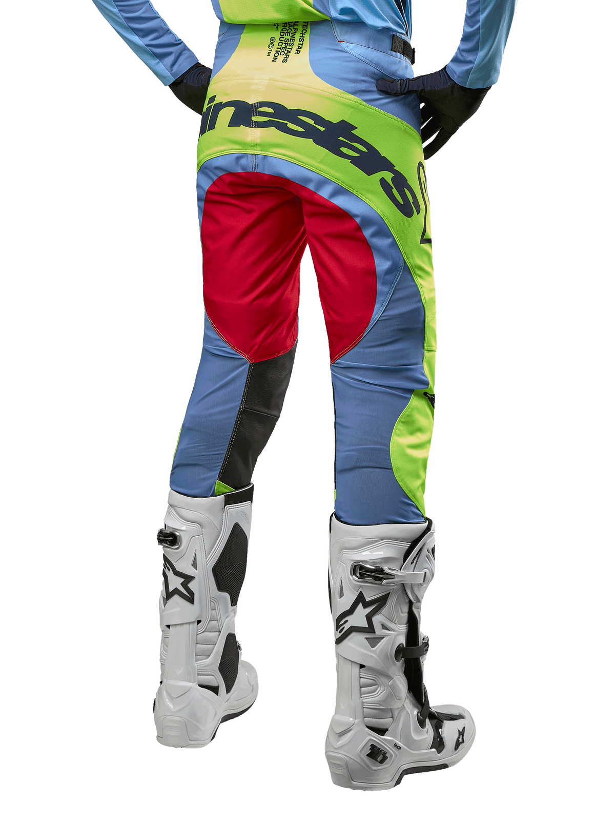 Calças Alpinestars 2024 Techstar Ocuri, calças de motocross, azul claro, amarelo néon e vermelho, vista traseira com botas de motocross brancas e pretas, com blocos de cores vibrantes e logótipo Alpinestars no assento