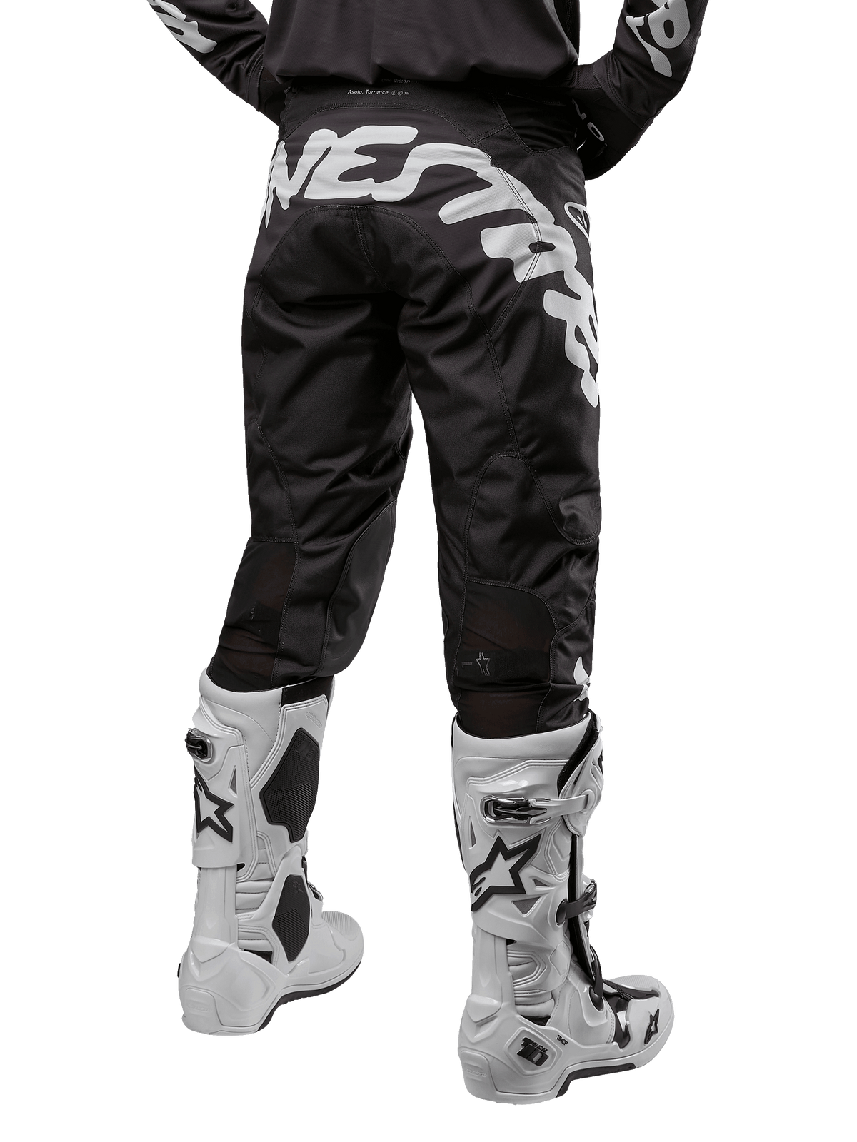 Alpinestars 2024 Racer Hana Pants, calças de motocross em preto e branco, vista traseira com grande logótipo de marca na zona do assento, design ergonómico, corte desportivo, combinadas com botas de motocross brancas