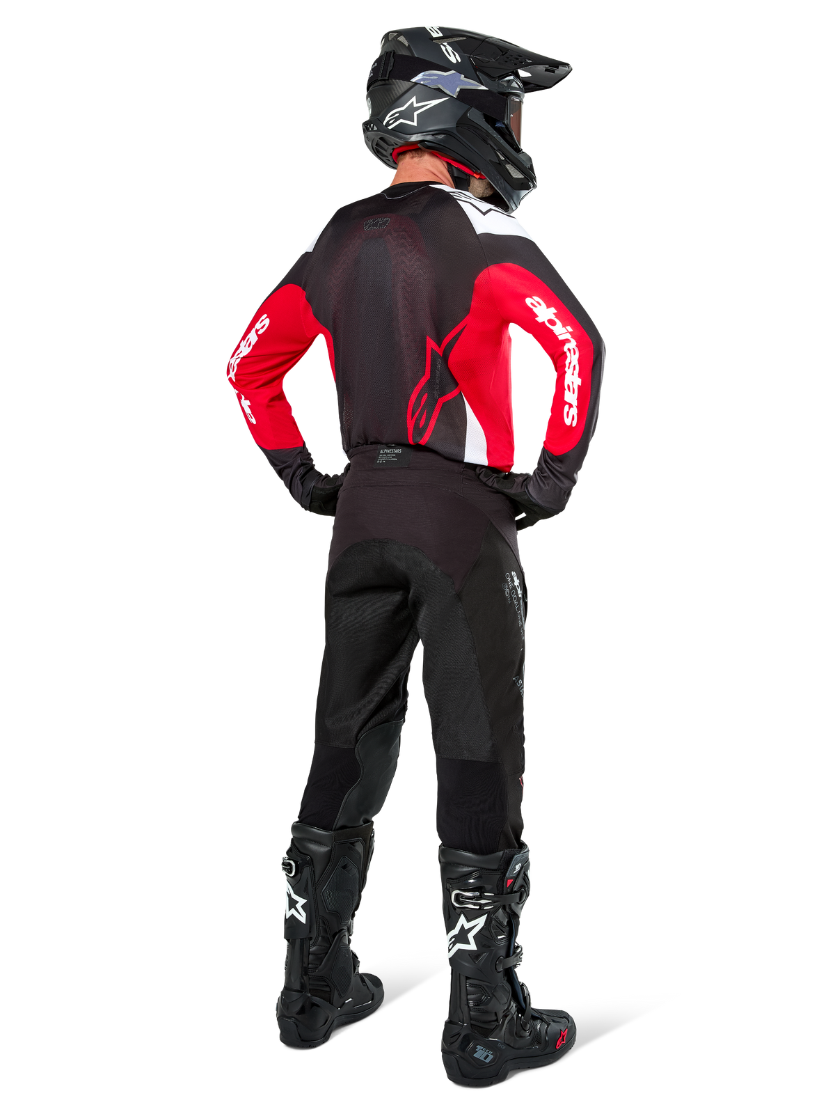 Piloto de motocross visto de costas com a camisola Alpinestars Pro-Dura em preto, vermelho brilhante e branco, combinada com calças, capacete e botas de motocross em preto, detalhe do design traseiro e logótipos nas mangas, equipamento de corrida todo-o-terreno