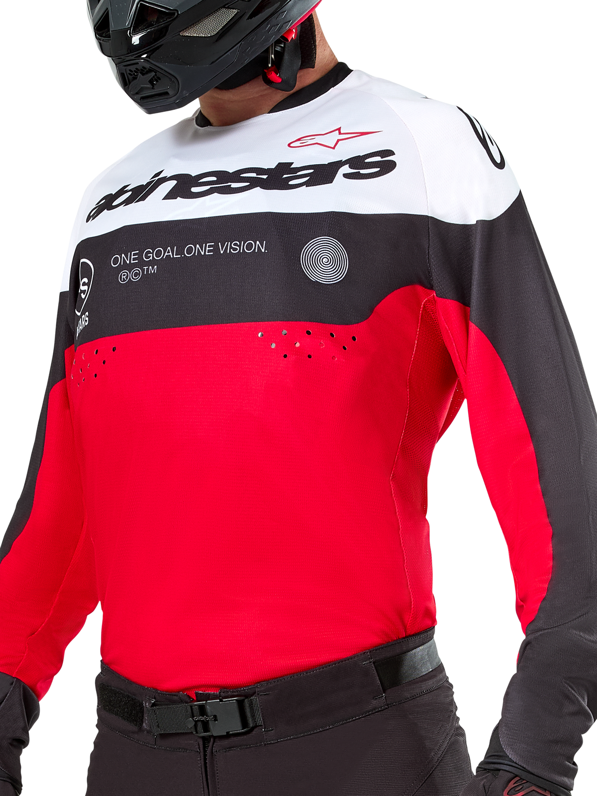 Alpinestars Pro-Dura Jersey, camisola de motocross e enduro, preta, vermelho brilhante e branca, com o grafismo 'ONE GOAL. ONE VISION.' e perfurações a laser no peito, usada com calças de motocross pretas e capacete.