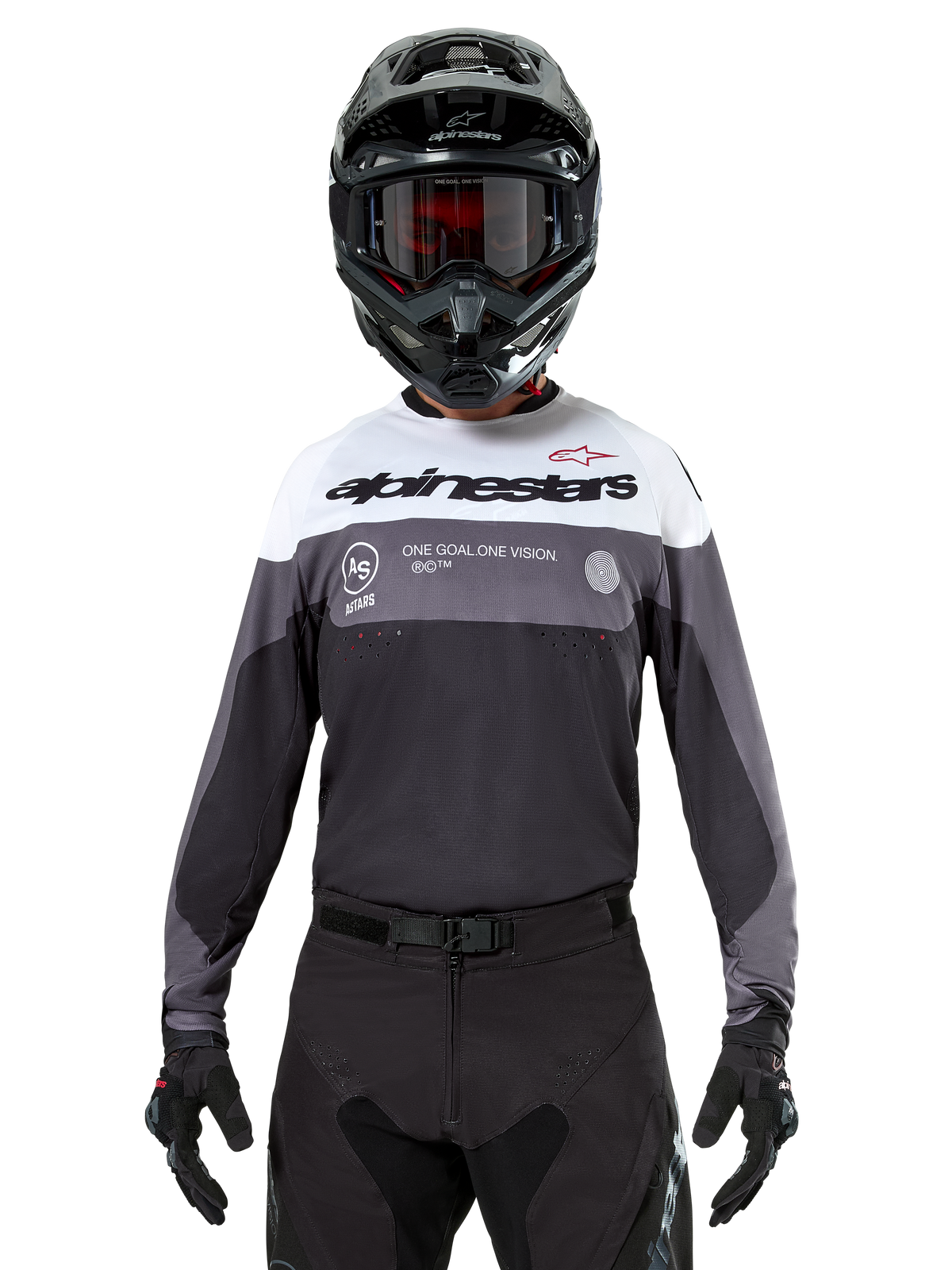 Piloto de motocross a usar a camisola Alpinestars Pro-Dura em Black Magnet White, camisola de performance de manga comprida com blocos de cor brancos e cinzentos, usada com um capacete e óculos pretos, com a marca 'alpinestars' e o slogan 'ONE GOAL ONE VISION', vestuário de corrida de motociclismo todo-o-terreno