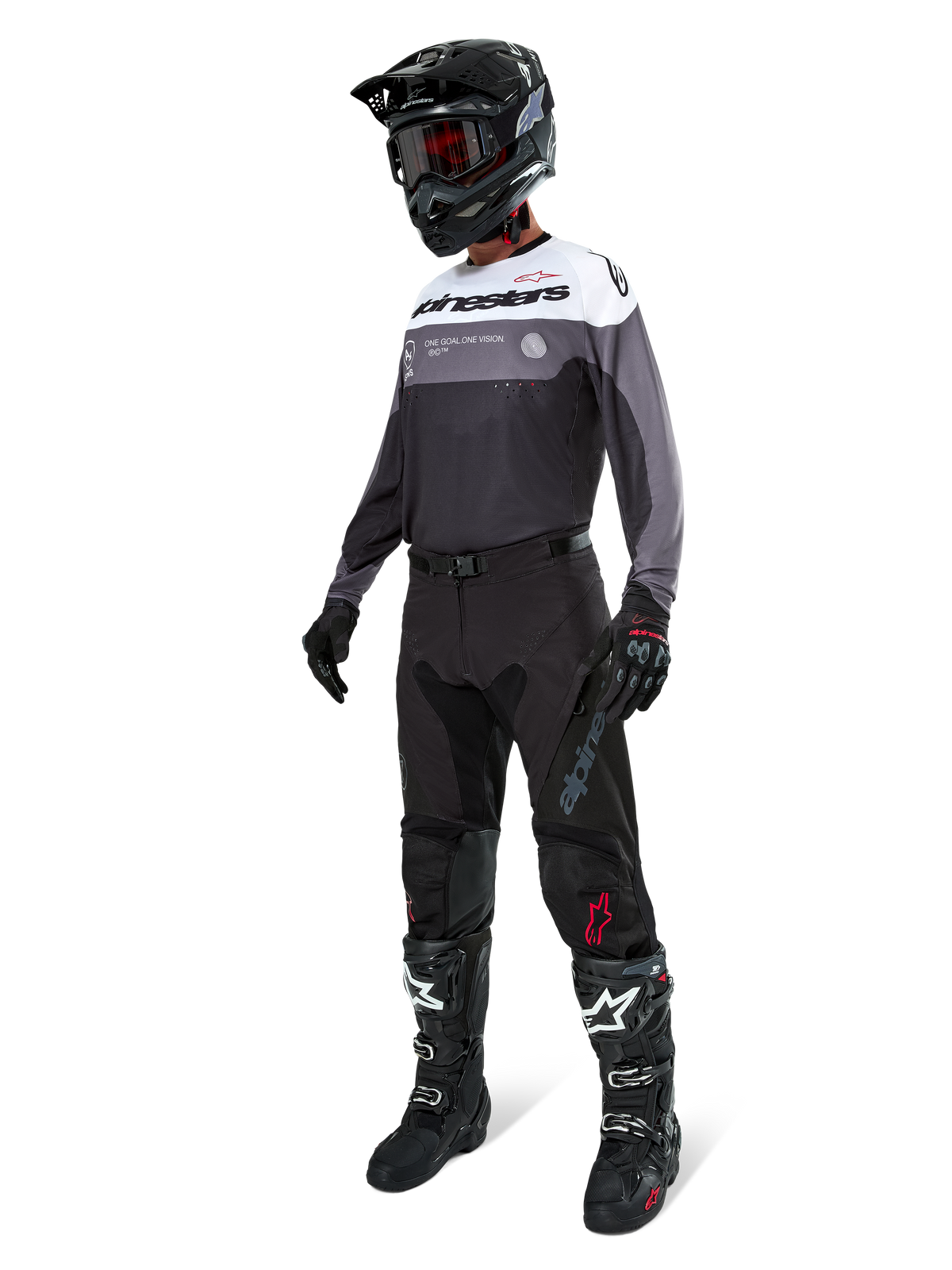 Camisola Alpinestars Pro-Dura em Black Magnet White, vestida por um piloto de motocross com equipamento completo, incluindo calças pretas, capacete preto com óculos e botas pretas e brancas. A camisola apresenta um design técnico de blocos de cor com painéis brancos, cinzentos e pretos, concebida para performance em enduro e todo-o-terreno.