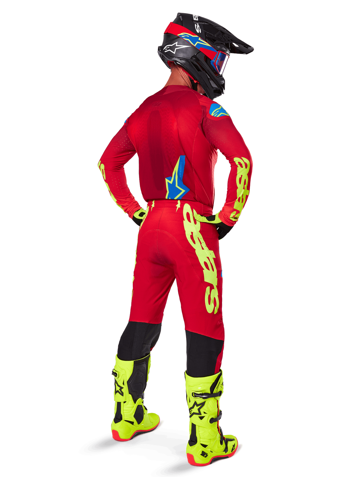 Piloto de motocross visto de costas com a camisola Alpinestars 2025 Supertech Maker, em vermelho brilhante e amarelo fluo, calças a condizer com logótipos amarelos, botas amarelas fluo e capacete preto e vermelho, equipamento coordenado para corridas de todo-o-terreno de nível profissional