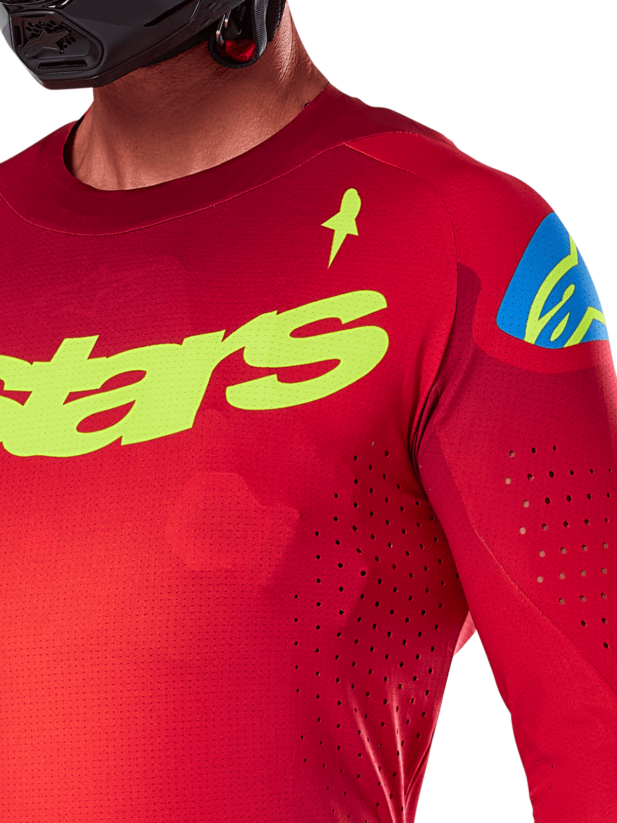 Alpinestars 2025 Supertech Maker Jersey, camisola de motocross, vermelho vivo e amarelo fluorescente, vista de pormenor das perfurações cortadas a laser, logótipo Alpinestars amarelo no peito, detalhe azul no ombro, tecido de malha elástica respirável