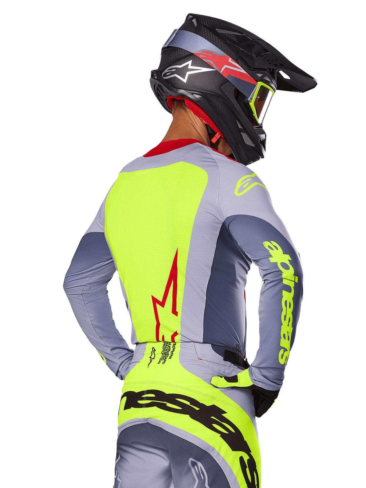 Camisola Alpinestars 2025 Techstar Melt Jersey, Bright Red Gray, vista traseira de um piloto de motocross com equipamento cinzento e amarelo néon, logótipo de estrela vermelha nas costas, capacete preto e vermelho a condizer, vestuário de performance para todo-o-terreno