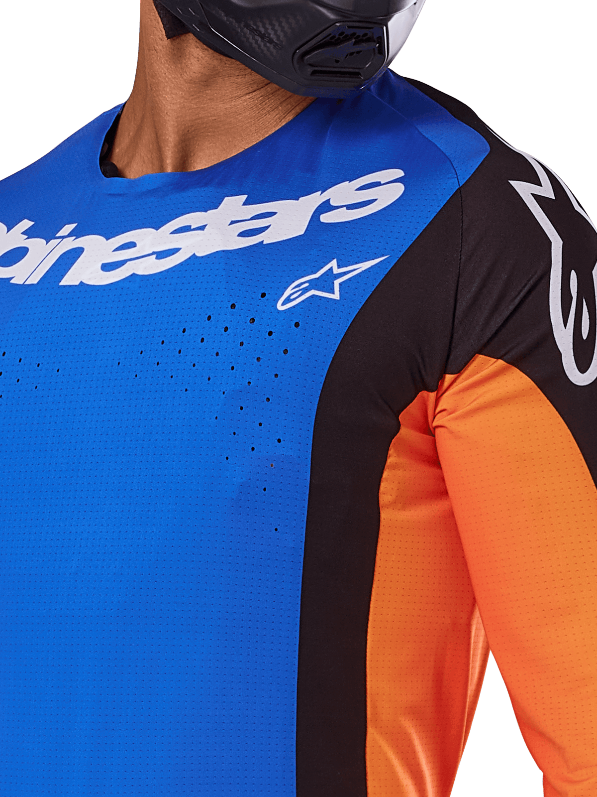 Alpinestars 2025 Techstar Melt Jersey, camisola de motocross, azul e laranja com painéis pretos, com logótipo Alpinestars em branco e perfurações a laser visíveis no peito, usada por um piloto com capacete preto
