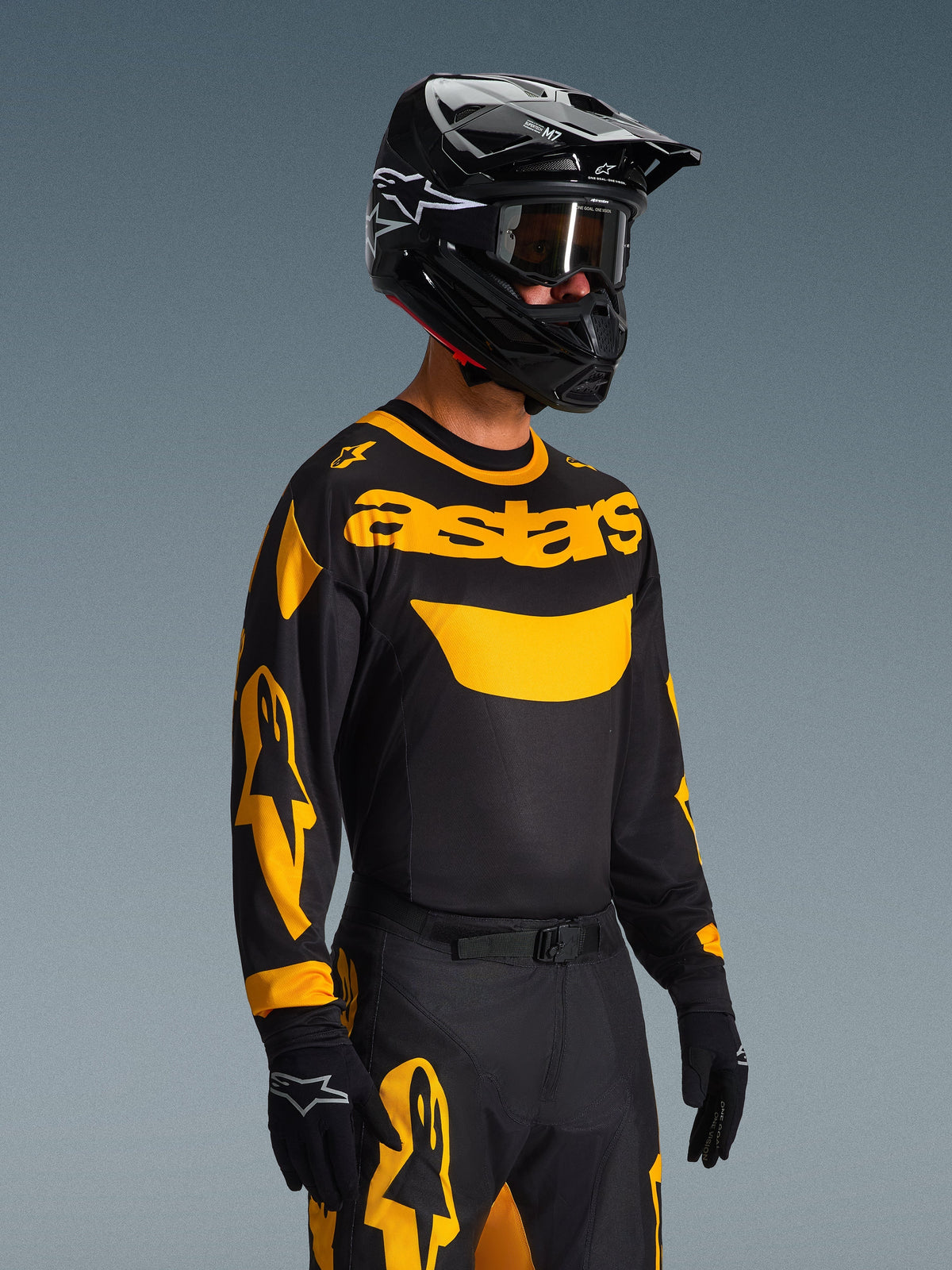 2026 Racer Riway Gear Set, Motocross rider wearing black jersey with yellow 'astars' branding and sleeve accents, matching black and yellow pants, black helmet with goggles and black gloves, coordinated off-road racing outfit
