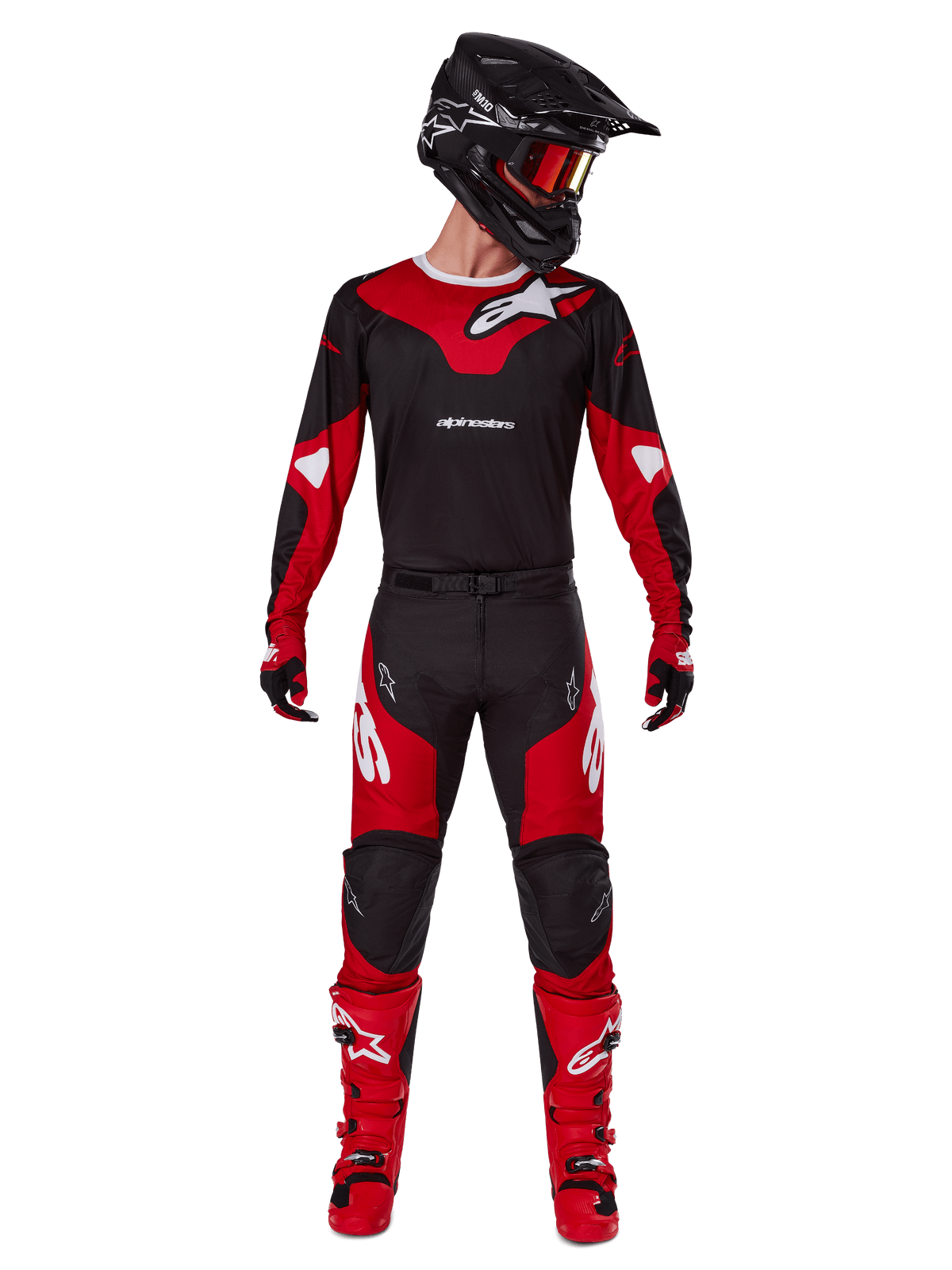Piloto de motocross a usar o conjunto de equipamento Alpinestars Racer Veil 2025, camisola preta e vermelho vivo com logótipo Alpinestars branco, calças de motocross a condizer, capacete preto com óculos vermelhos e botas vermelhas, conjunto completo de performance para condução todo-o-terreno