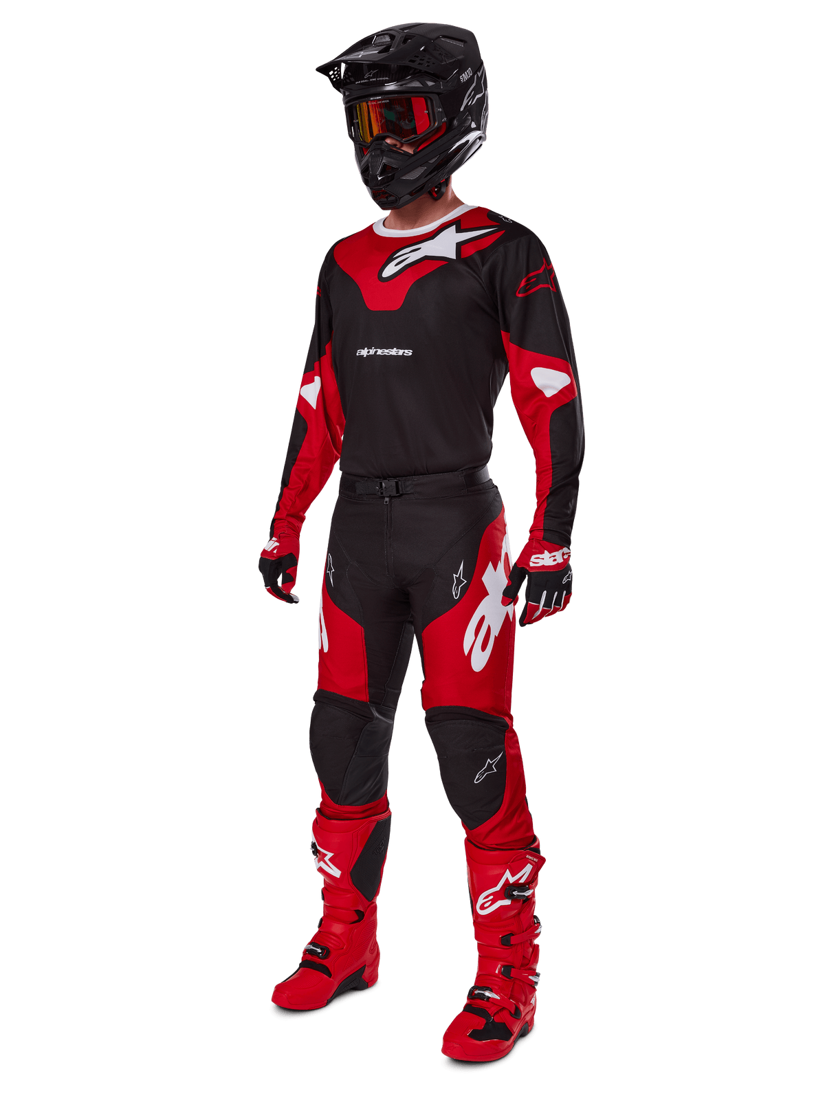 Piloto de motocross a usar equipamento de corrida completo com a camisola Alpinestars 2025 Racer Veil em preto e vermelho vivo, calças a condizer, botas vermelhas, capacete preto com óculos vermelhos e luvas vermelhas e pretas, visual de performance coordenado para corridas de todo-o-terreno