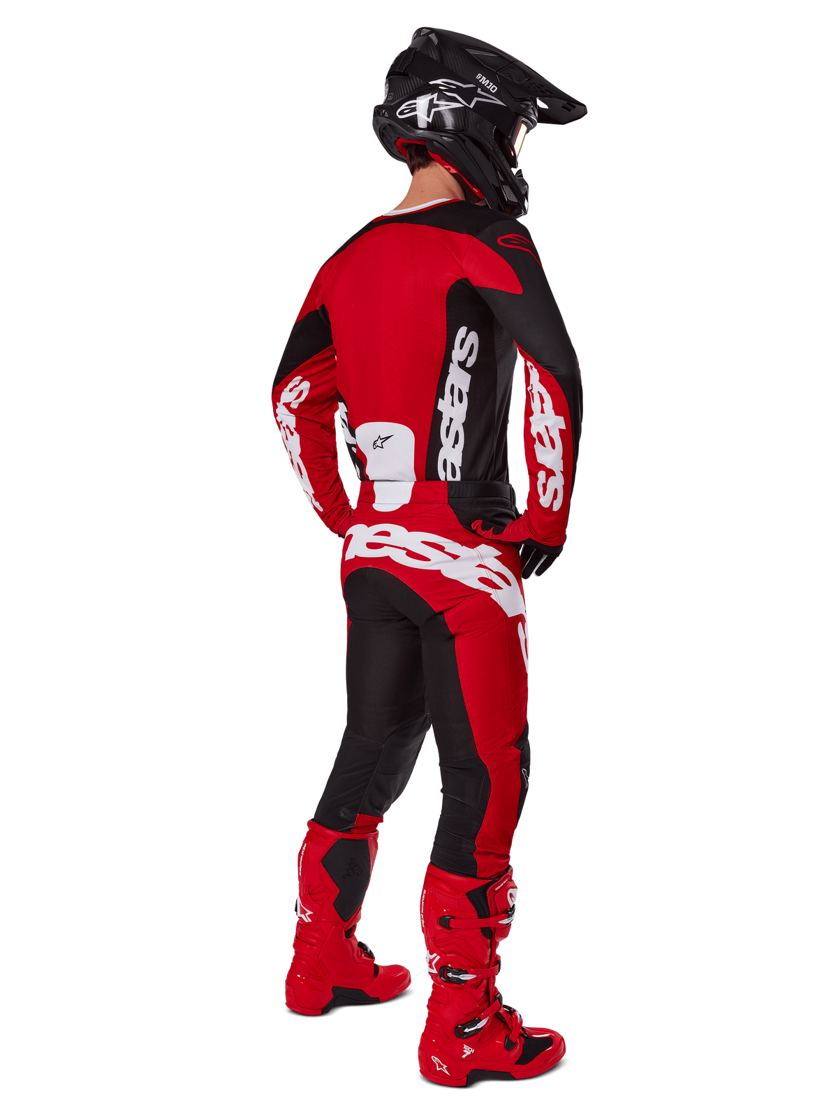 Piloto de motocross visto de costas a usar a camisola Alpinestars 2025 Racer Veil em preto e vermelho brilhante, coordenada com calças vermelhas e pretas a condizer e botas de motocross vermelhas, com grandes logótipos brancos, ideal para desempenho todo-o-terreno