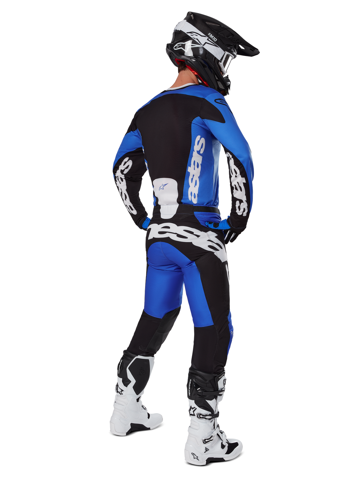 Piloto de motocross visto de costas com equipamento completo, camisola 2025 Racer Veil e calças a condizer em azul e preto, com logótipo Alpinestars branco, capacete preto e botas brancas e pretas, conjunto coordenado para corridas todo-o-terreno