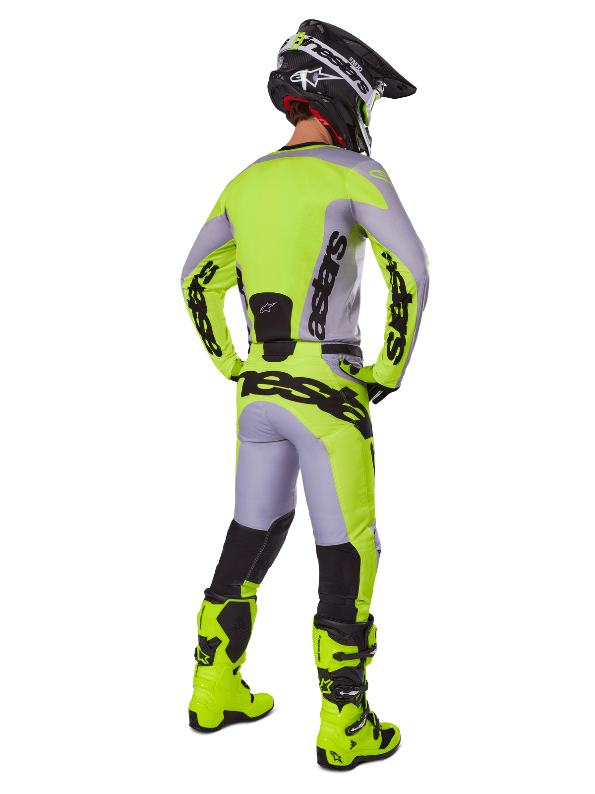 Piloto de motocross visto de costas com o conjunto de equipamento Alpinestars 2025 Racer Veil, camisola e calças em cinzento e amarelo néon, botas amarelo néon e capacete preto e amarelo, visual coordenado para competição todo-o-terreno