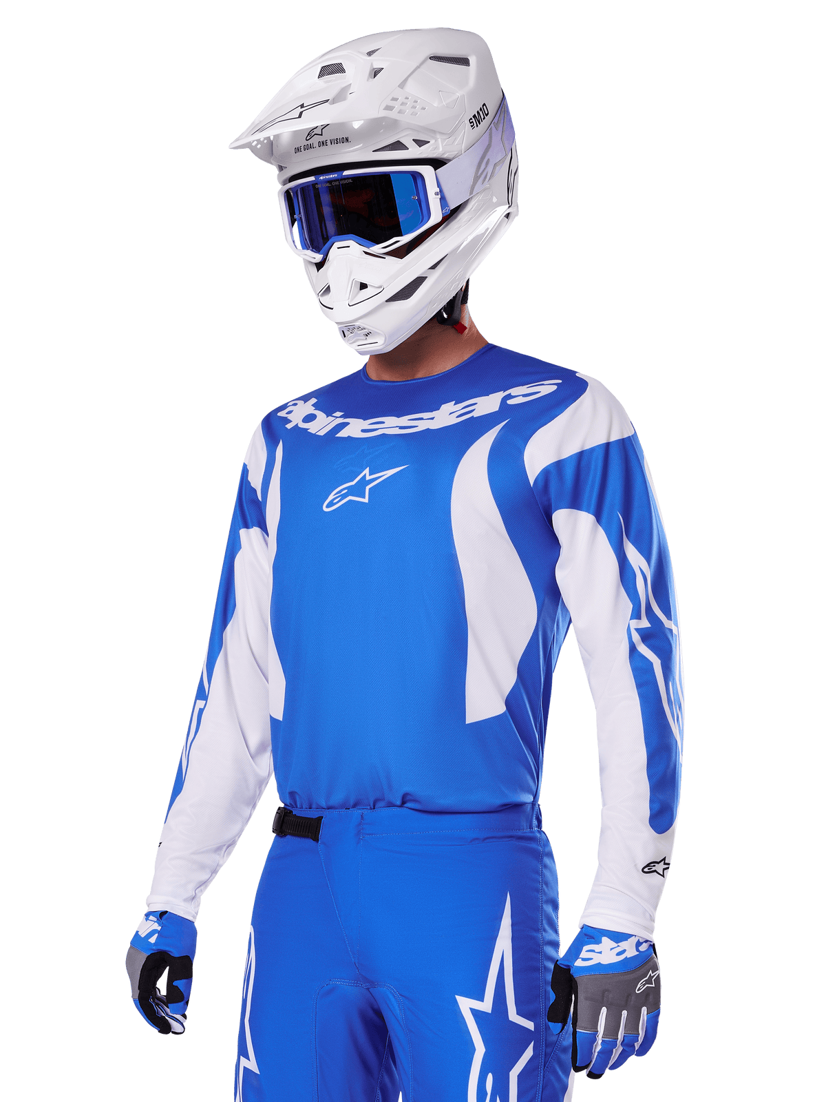 Piloto de motocross com o conjunto de equipamento Alpinestars 2025 Fluid Haul em azul e branco, camisola azul com detalhes brancos, calças azuis com logótipos de estrela, capacete branco com óculos azuis e luvas em azul e cinzento, equipamento completo de corrida todo-o-terreno