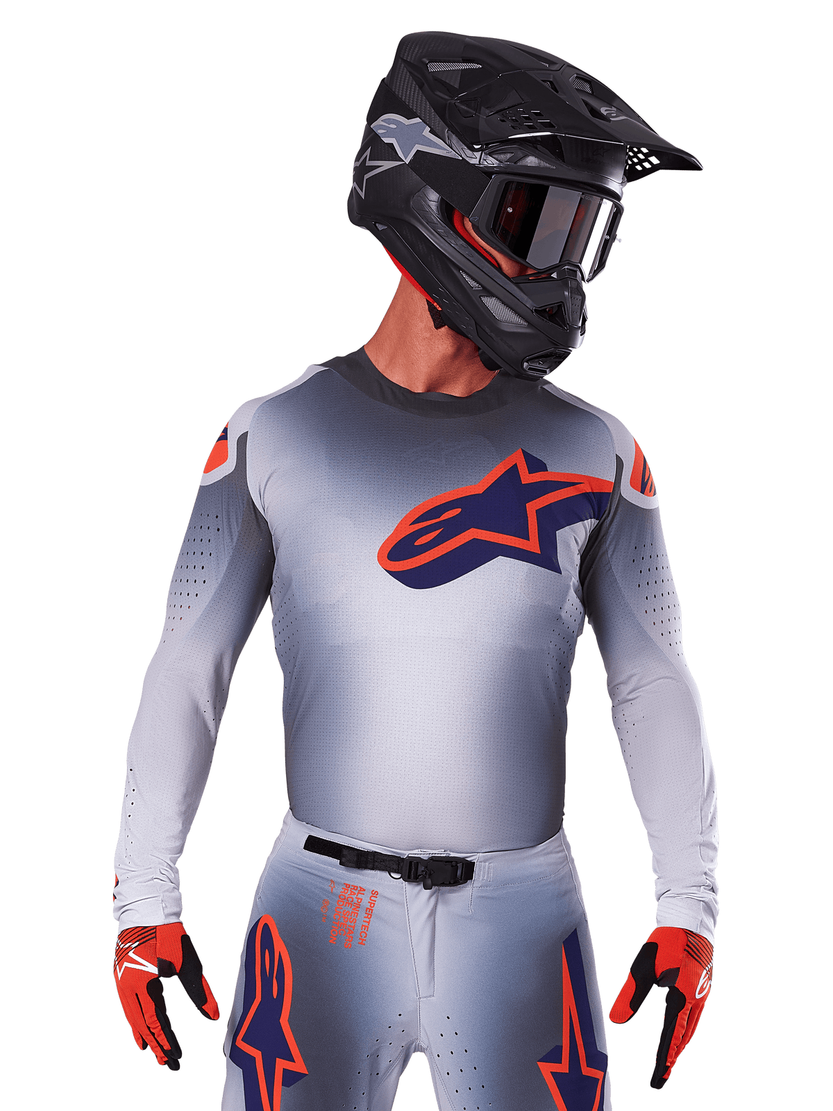 Camisola Alpinestars Supertech Lipan 2025, camisola de motocross, cinzenta com detalhes em laranja e azul-marinho, camisola de performance de manga comprida com detalhes de ventilação perfurados, usada com capacete preto e luvas vermelhas, design de corrida elegante