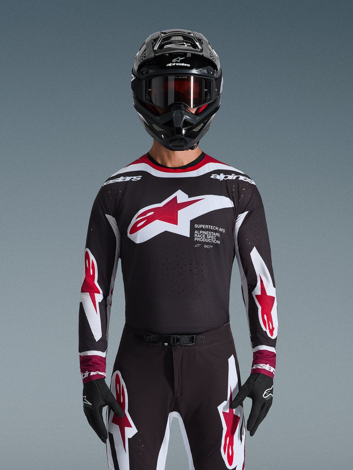 Alpinestars 2026 Supertech AFD Vista Gear Set, Motocross Gear Set, black jersey with red and white logos and 'Supertech AFD' branding, matching black pants with red accents, black helmet with red goggles, coordinated professional racing outfit
