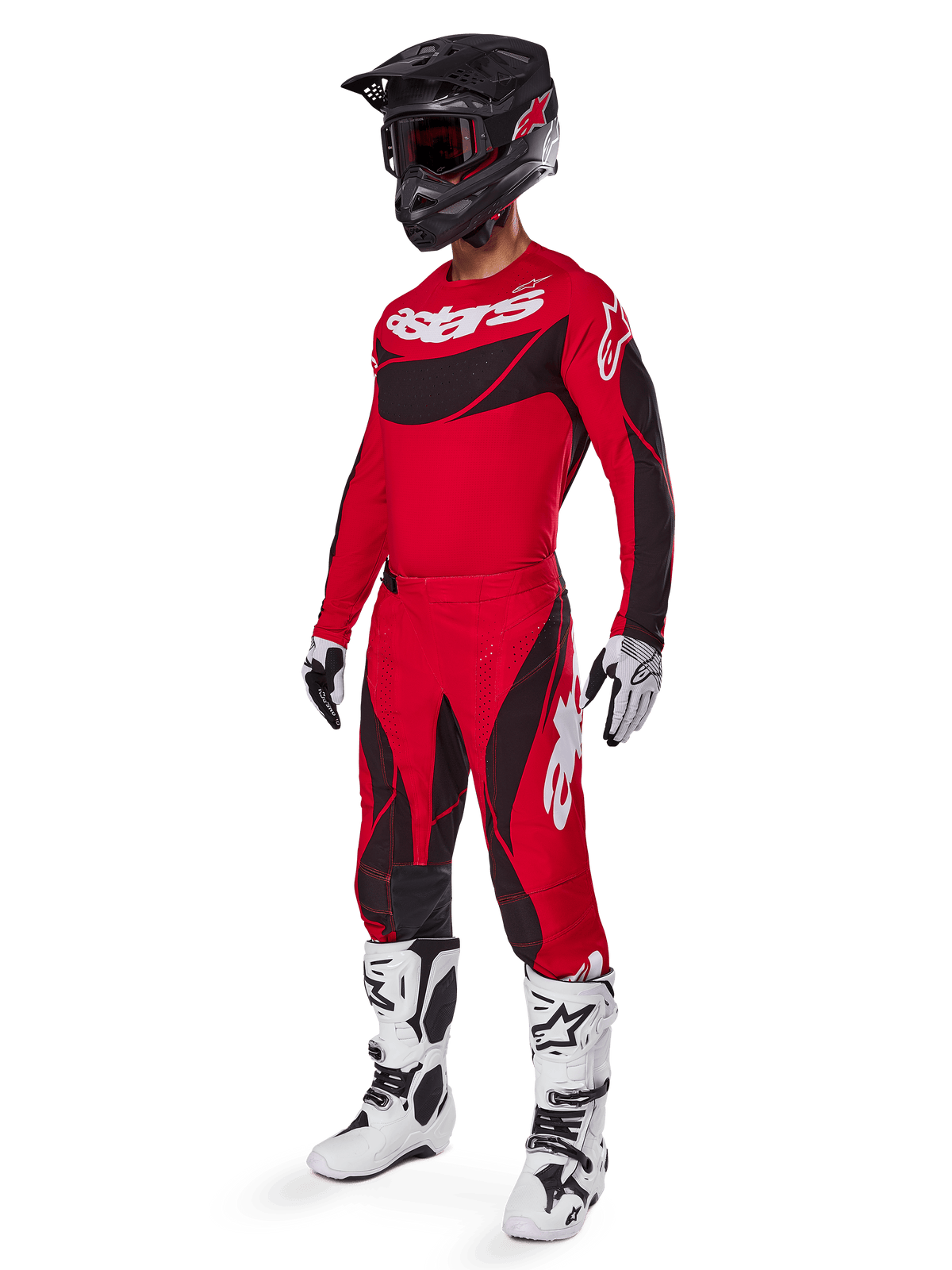 Vista de corpo inteiro de um piloto de motocross com o conjunto de equipamento Techstar Dreem 2025 em vermelho brilhante e preto, composto por camisola de performance com logótipo branco, calças ripstop elásticas a condizer, capacete preto com viseira vermelha, luvas brancas e pretas e botas Tech brancas, fato de corrida especializado para competição todo-o-terreno.
