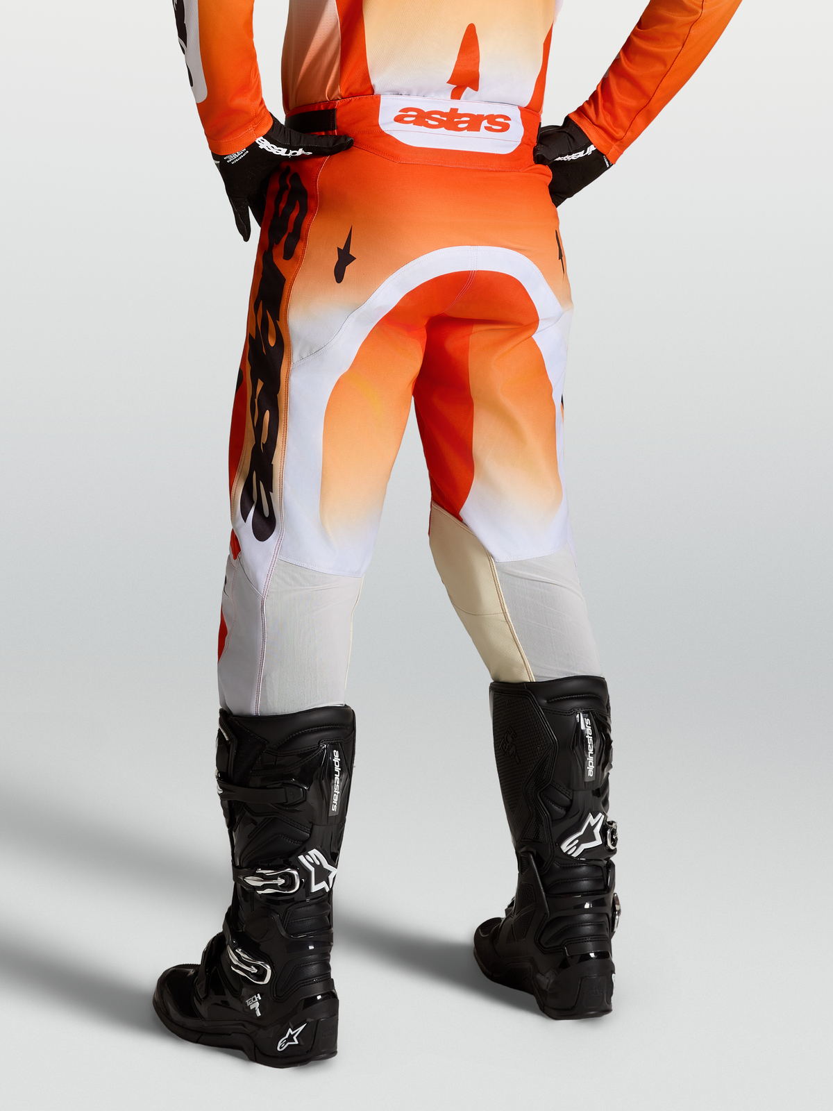 Alpinestars Calças Racer Amber, calças de motocross para homem, cor de laranja e branco, vista traseira e botas pretas