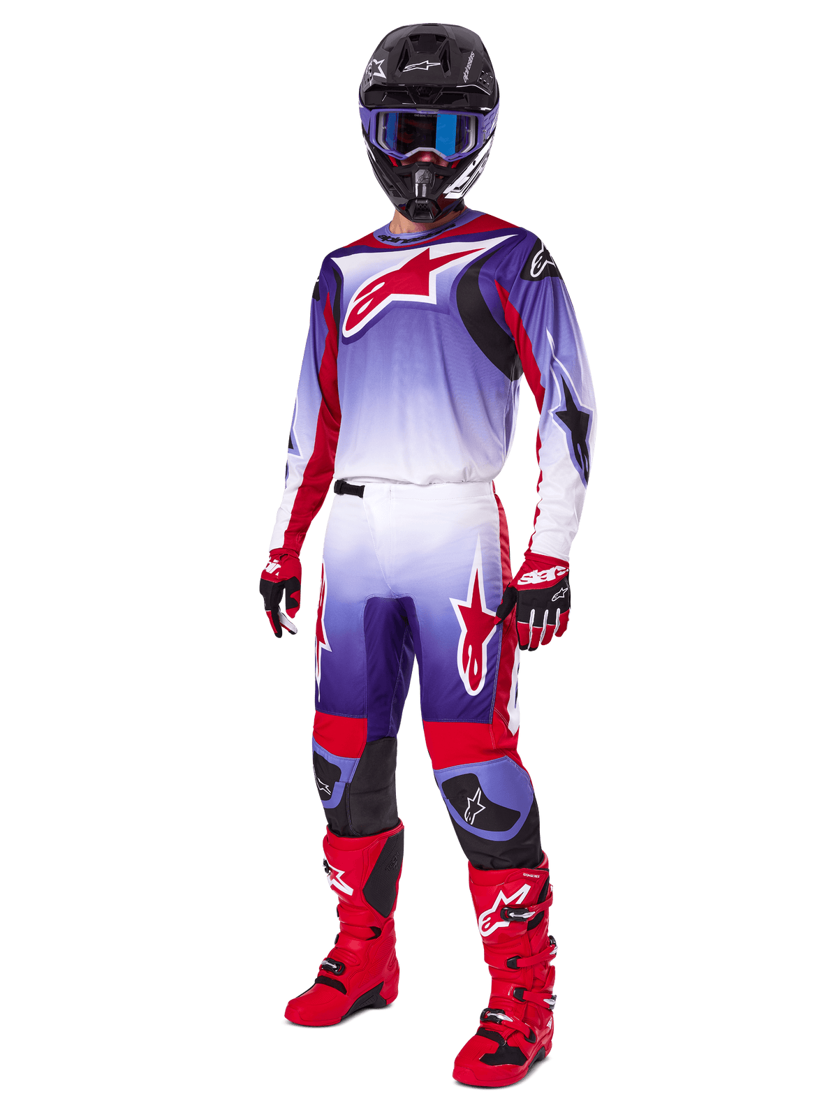Piloto de motocross a usar o Conjunto de Equipamento Alpinestars 2025 Fluid Wurx, camisola roxa e vermelho vivo com detalhes brancos, calças de motocross a condizer, botas vermelho vivo, capacete preto com óculos de proteção azuis, e luvas vermelhas e pretas, equipamento profissional completo para corridas todo-o-terreno