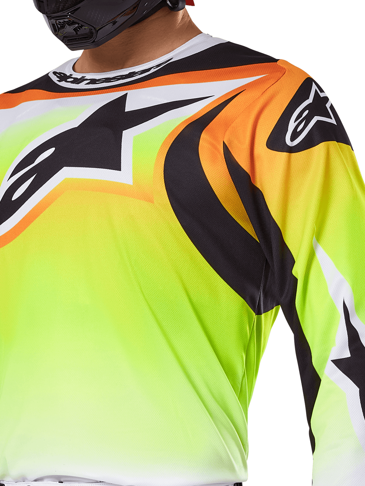 Camisola Alpinestars 2025 Fluid Wurx, camisola de motocross, amarelo fluorescente com grafismos pretos e cor-de-laranja, com um grande logótipo Alpinestars preto no peito e no ombro, usada por um piloto com capacete preto.