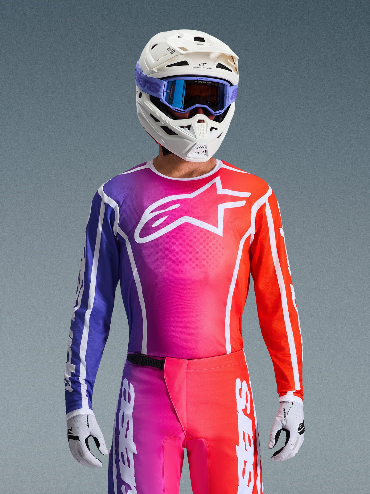 Alpinestars 2026 Fluid Apex Gear Set, camisola e calças de motocross com design em degradê roxo, rosa e laranja, logótipo de estrela Alpinestars branco no peito, capacete branco e óculos roxos, corte atlético de alta performance para condução todo-o-terreno