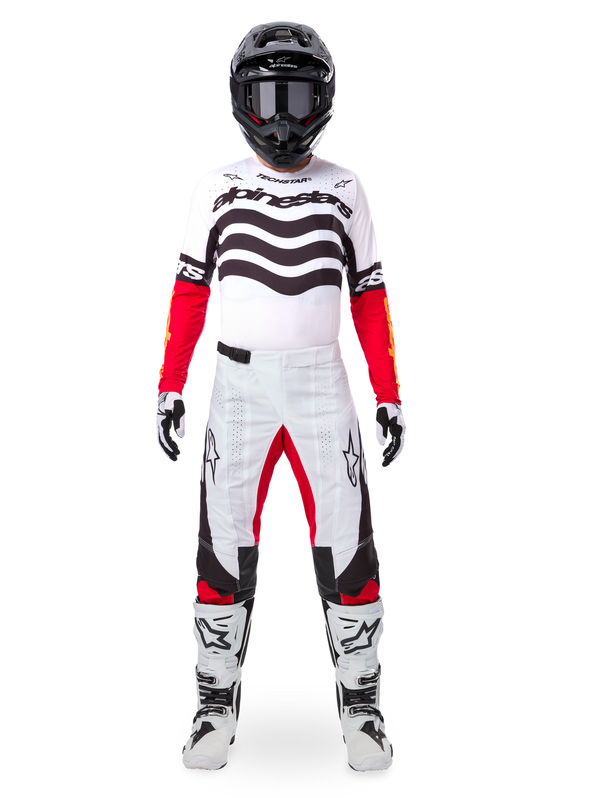 Piloto de motocross a usar o Conjunto Alpinestars Techstar Deep Edição Limitada, camisola branca com grafismos de ondas pretas e mangas vermelhas, calças brancas e pretas com detalhes vermelhos no interior das coxas, capacete preto com óculos escuros e botas brancas, equipamento profissional completo de corrida todo-o-terreno