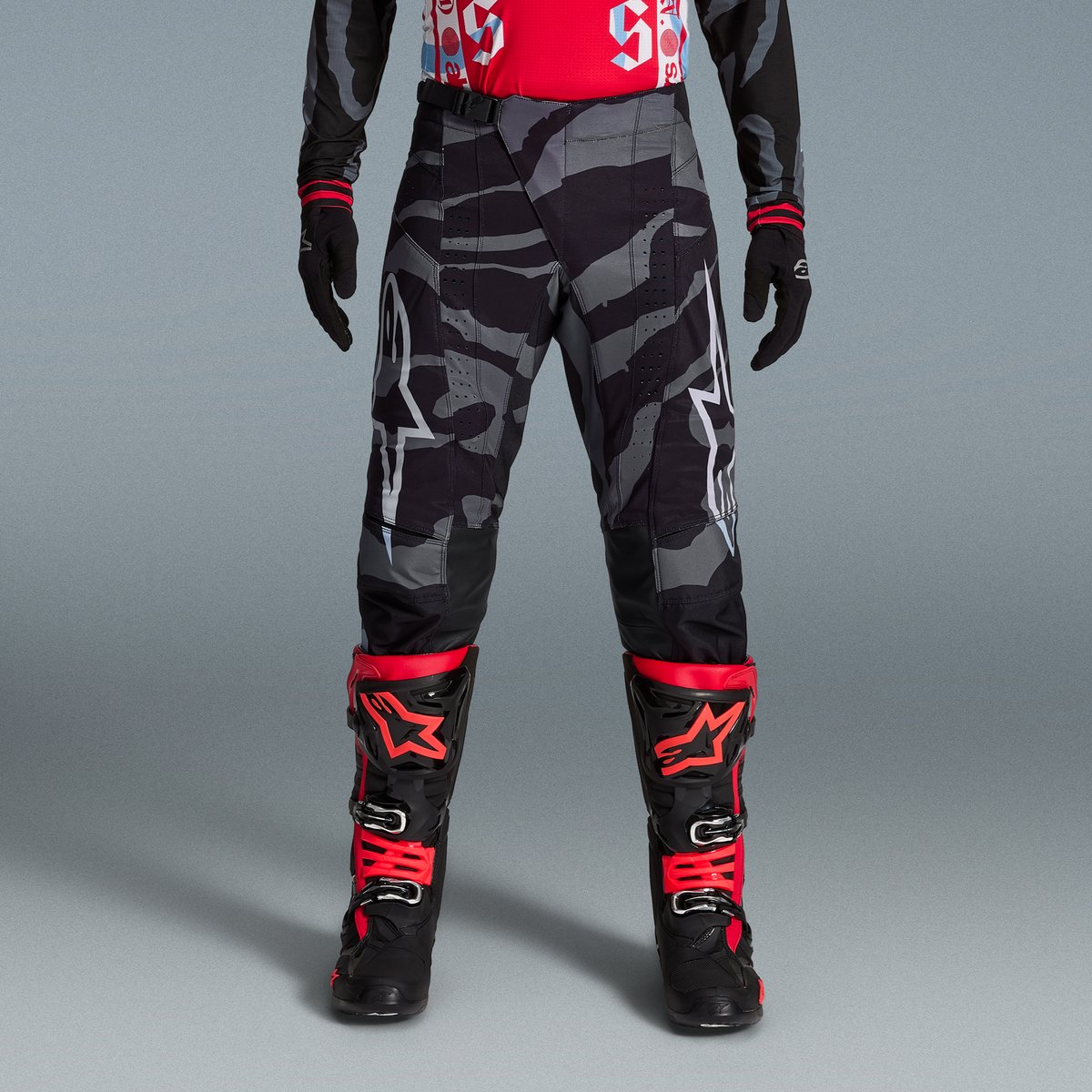 Calças Alpinestars Techstar Edição Limitada Beast Coast em camuflado cinza e botas vermelhas, equipamento de motocross.