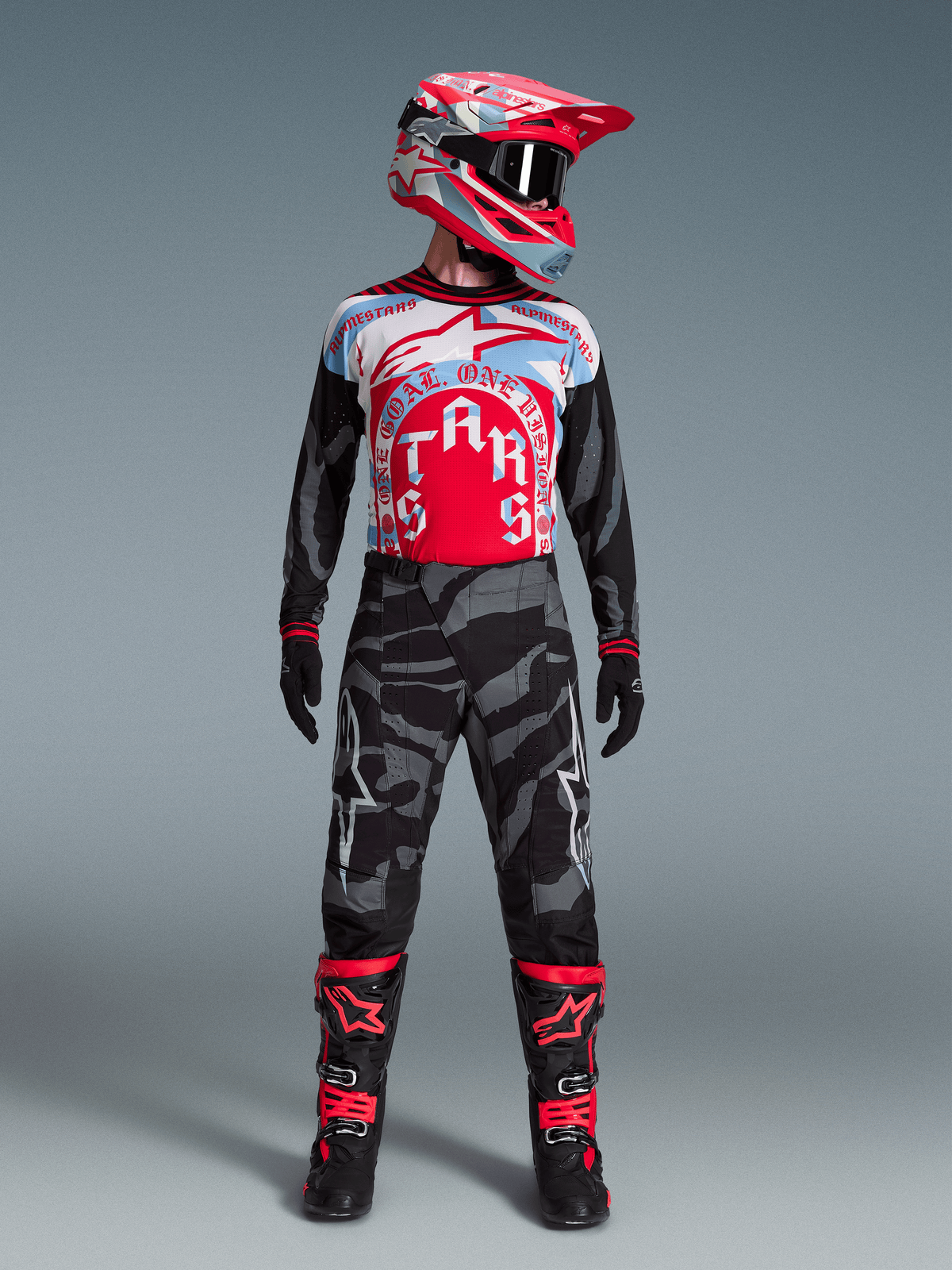 Camisola Techstar Beast Coast Edição Limitada, vermelha e azul, com calças camufladas e botas de motocross pretas.