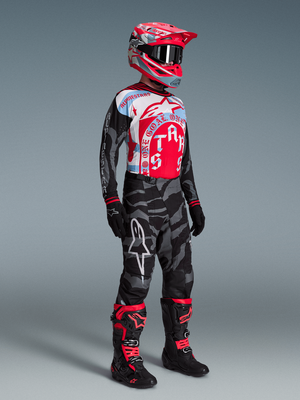 Conjunto Alpinestars Techstar Beast Coast Edição Limitada, piloto de motocross em camuflado preto, vermelho e azul.