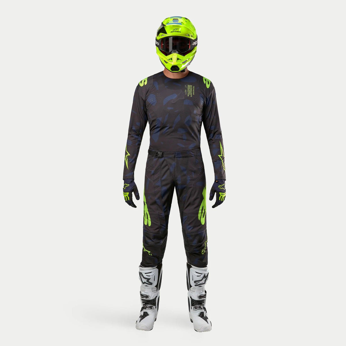 Piloto de motocross com equipamento de corrida completo, Camisola Techstar Rantera 2024 em preto, azul marinho e amarelo fluo, calças com padrão abstrato a condizer, capacete amarelo fluo brilhante, botas brancas e pretas, conjunto coordenado para corridas todo-o-terreno