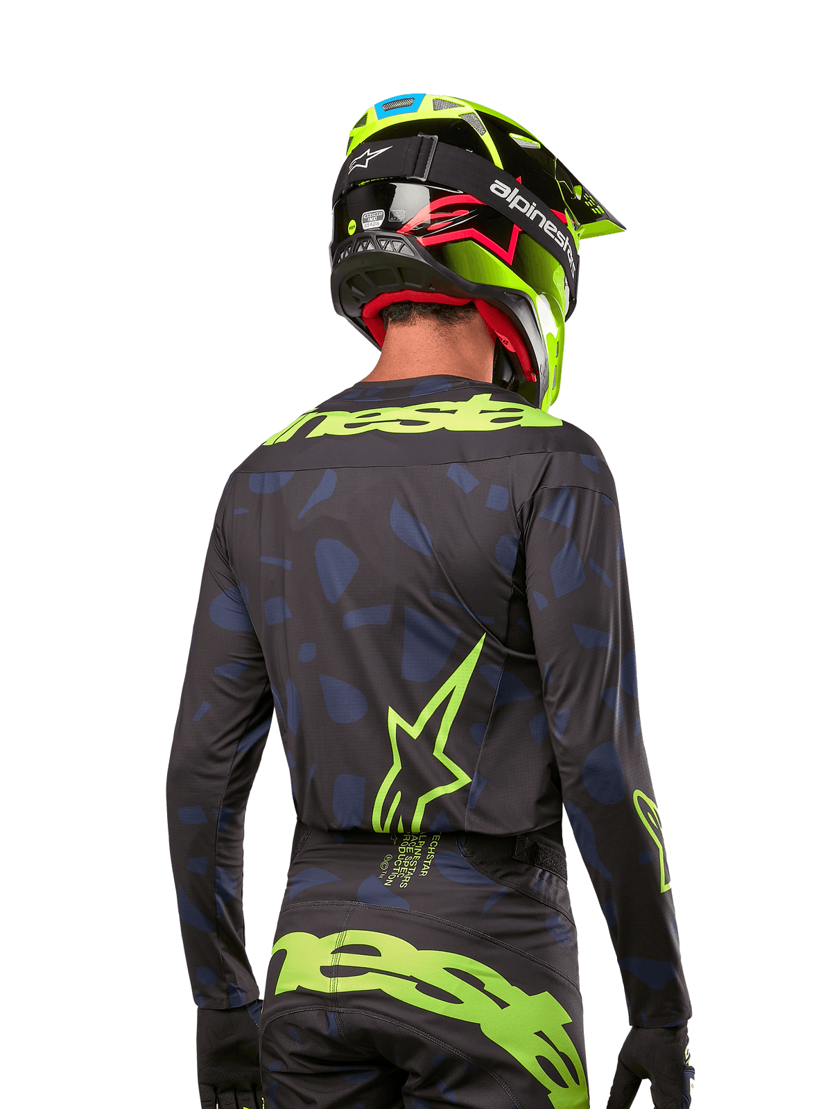 Vista traseira de um piloto de motocross a usar a camisola Alpinestars 2024 Techstar Rantera em Black Navy Yellow Fluo, com logótipos e marca em amarelo fluo proeminentes nas costas, combinada com calças de motocross a condizer e um capacete amarelo néon para um visual completo de corrida todo-o-terreno.